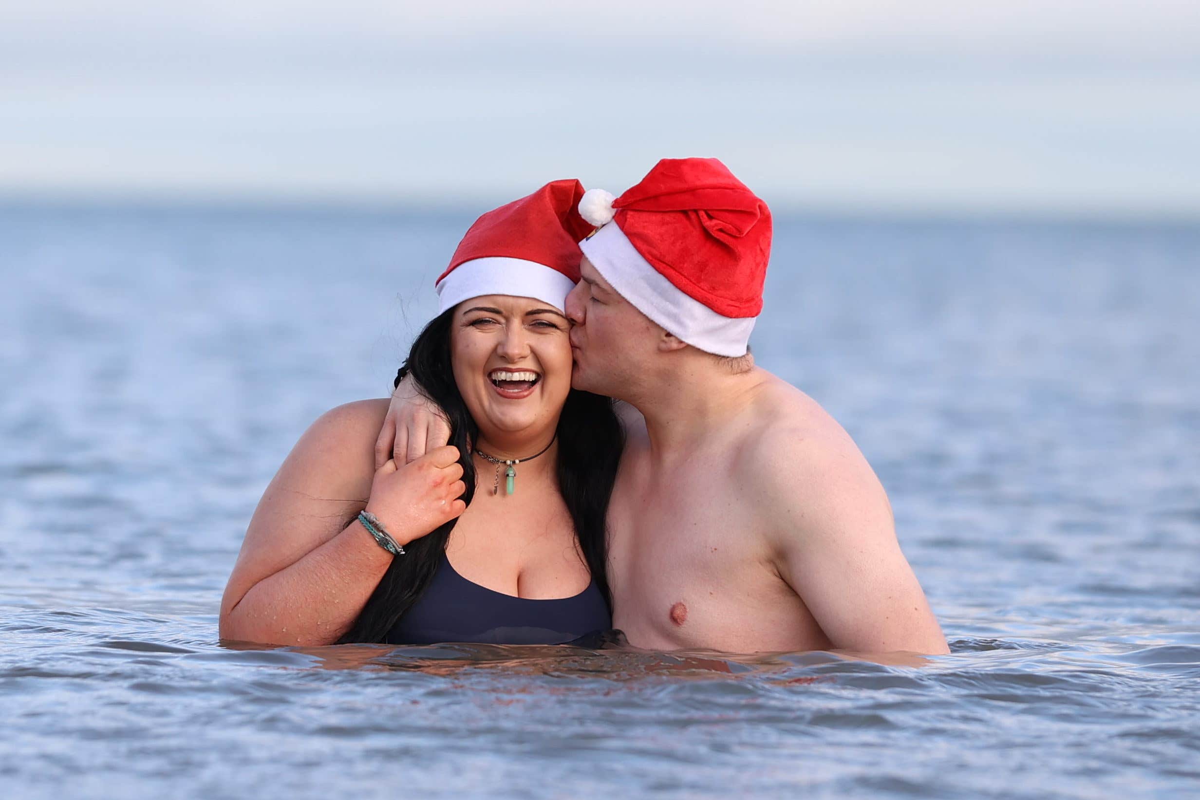 Rebecca Browne and Joel McElwee take part in the annual Christmas Eve swim at Helen’s Bay, Co Down (Liam McBurney/PA)