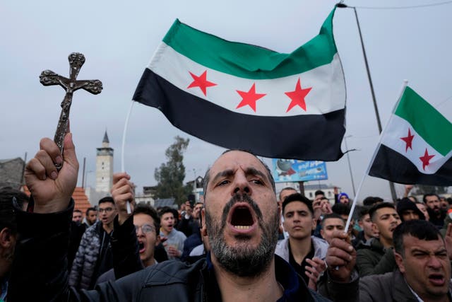 <p>Protesters with crosses in Damascus amid anger at the burning of a Christmas tree by masked men in the Syrian town of Suqaylabiyah</p>