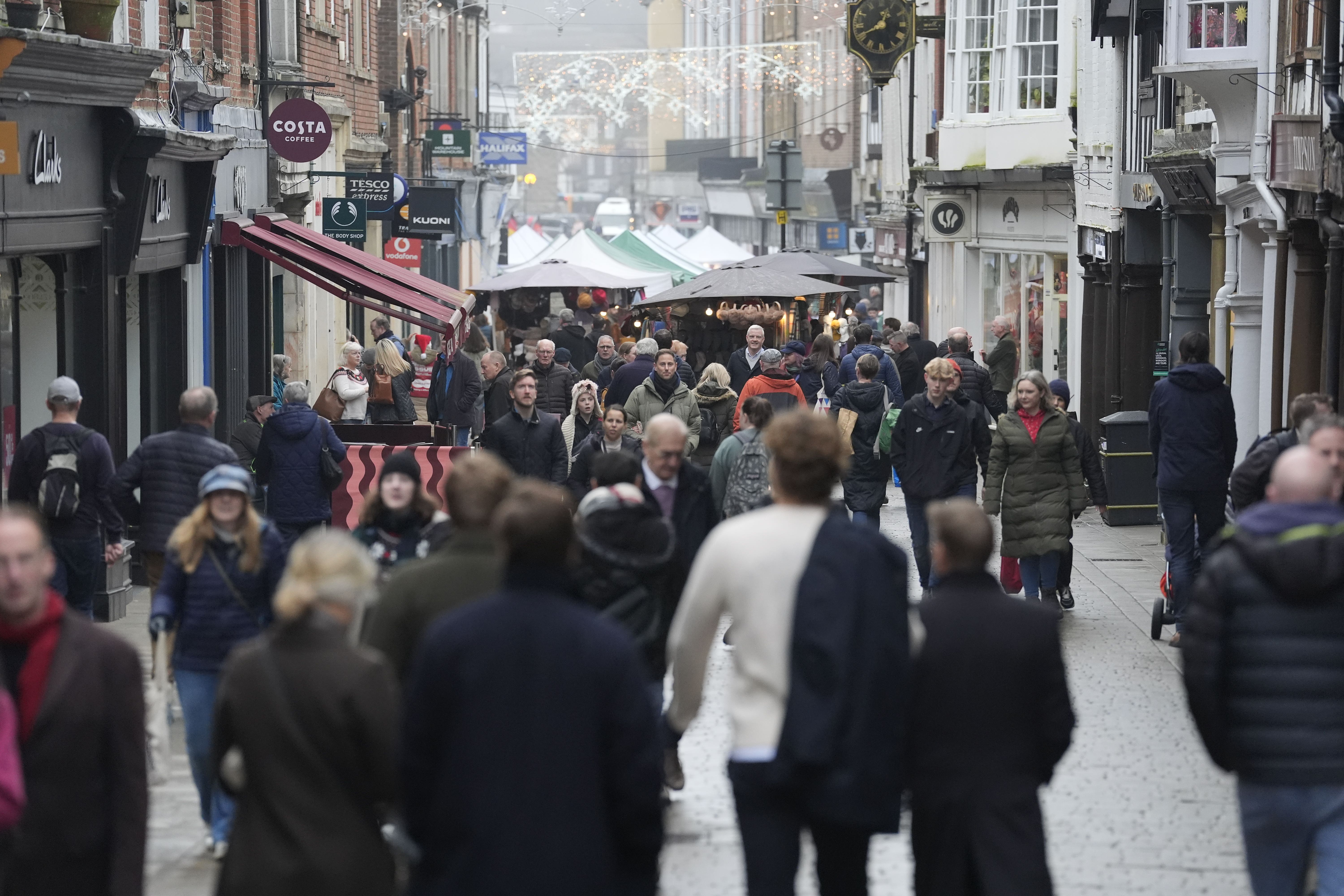 Last-minute shoppers on Christmas Eve make their way along the High Street in Winchester