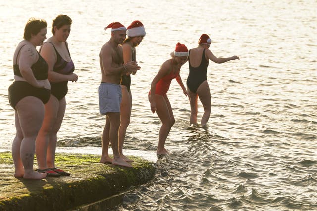 People take part in the Clontarf Yacht and Boat Club annual charity Christmas swim (Brian Lawless/PA)
