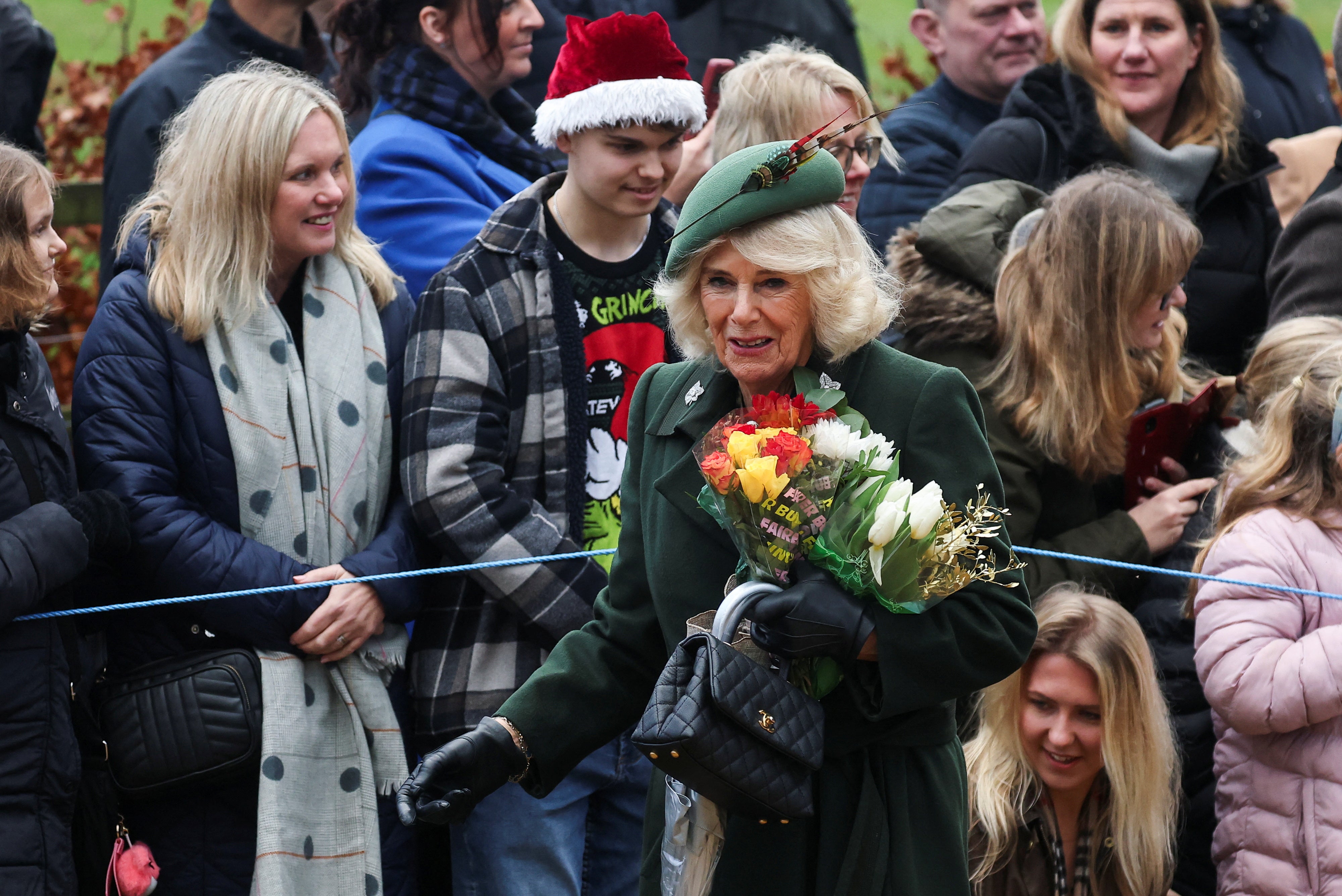 Queen Camilla clutches flowers on her way to church