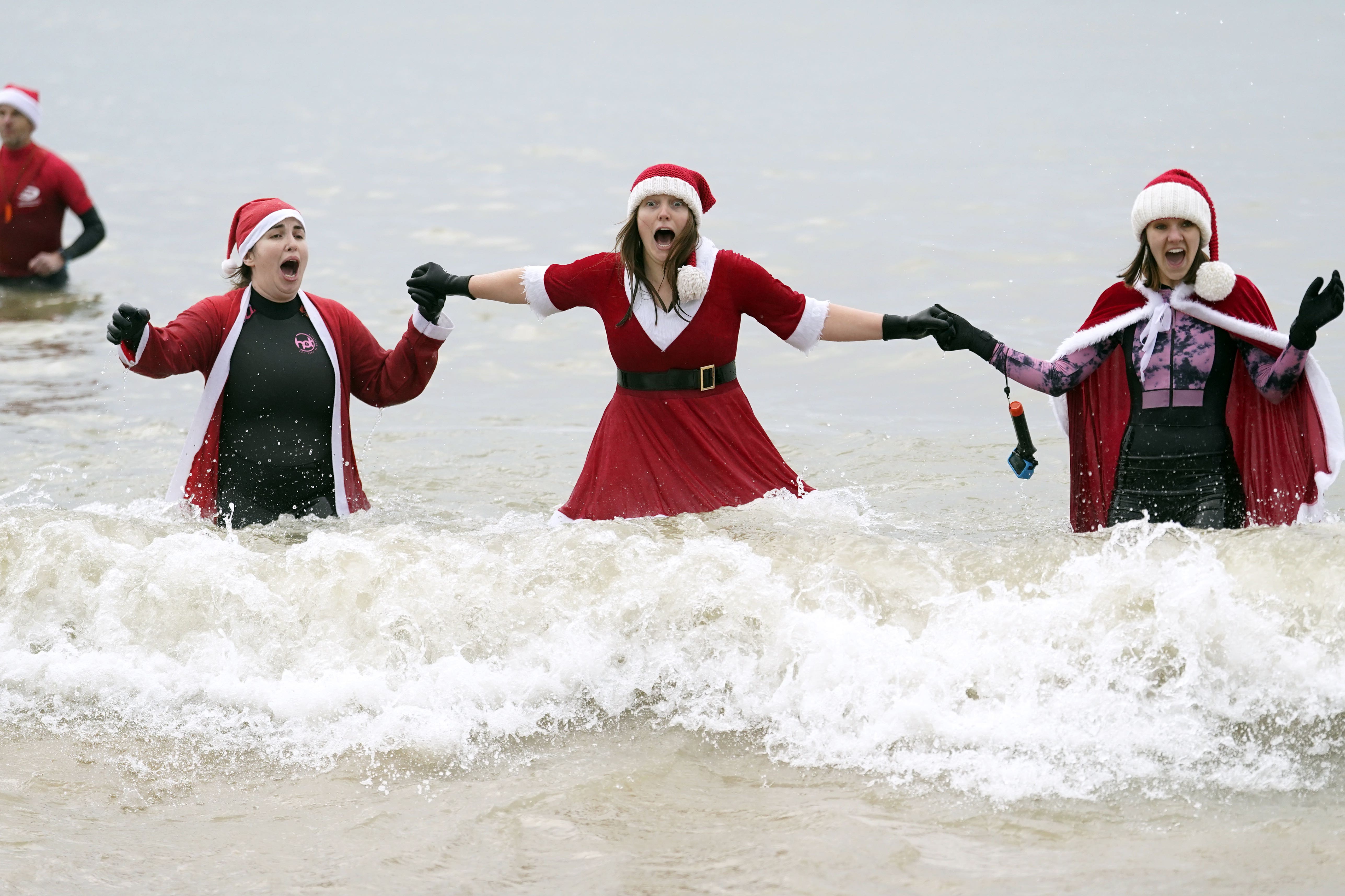 Swimmers take part in the Macmillan Boscombe White Christmas Dip, in aid of Macmillan Caring Locally, at Boscombe Pier in Bournemouth, Dorset on Christmas morning (Andrew Matthews/PA)