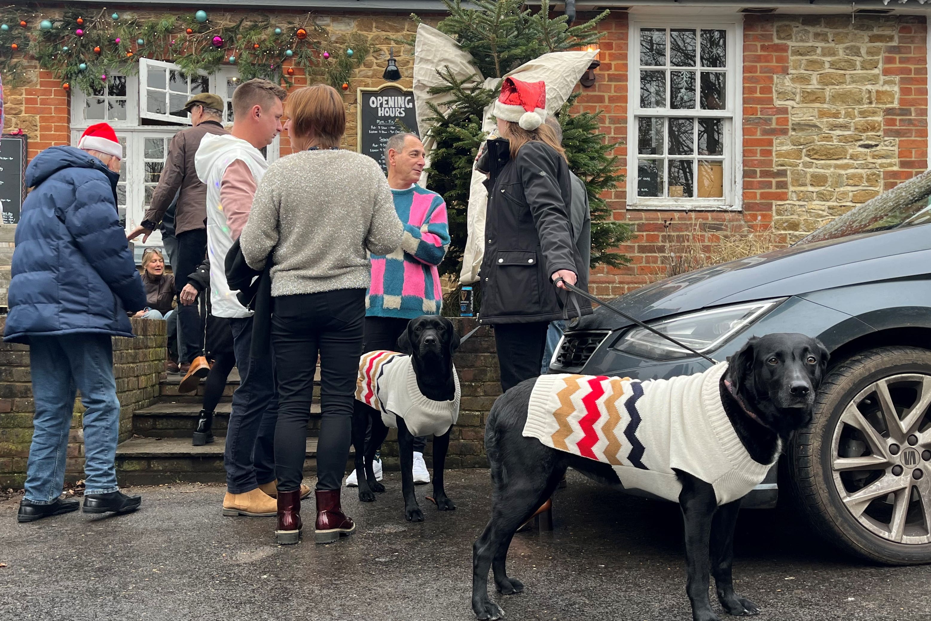 People enjoy a pre-Christmas lunch drink in the mild weather at the Holly Bush Pub, Frensham, Surrey (James Manning/PA)