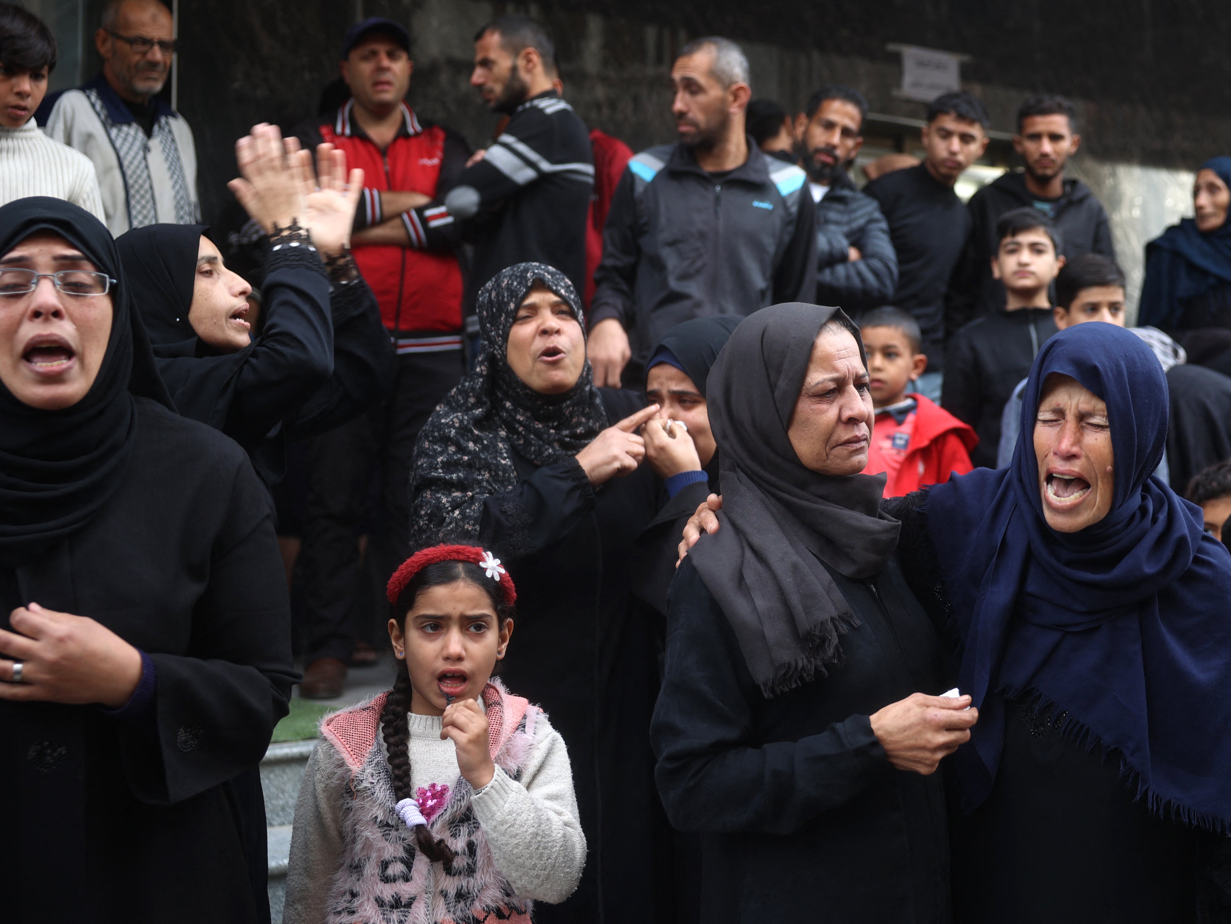 File. Palestinian women mourn relatives killed in an Israeli strike at al-Awda Hospital in the Nuseirat refugee Camp in the central Gaza Strip on 7 December 2024