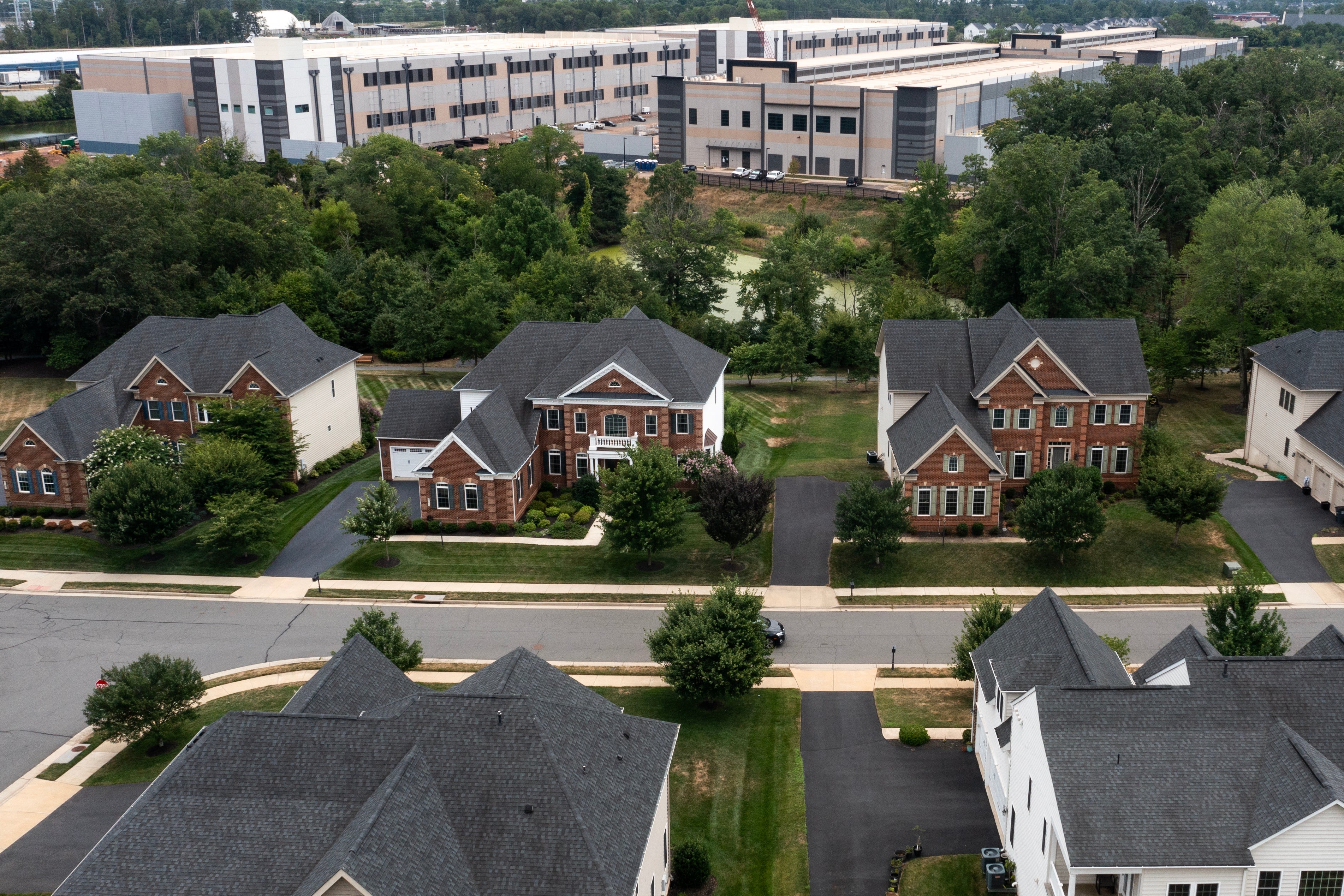 An Amazon Web Services data center is seen close to homes in Stone Ridge, Virginia, last July. New research is highlighting the health costs of new data centers being built across the US