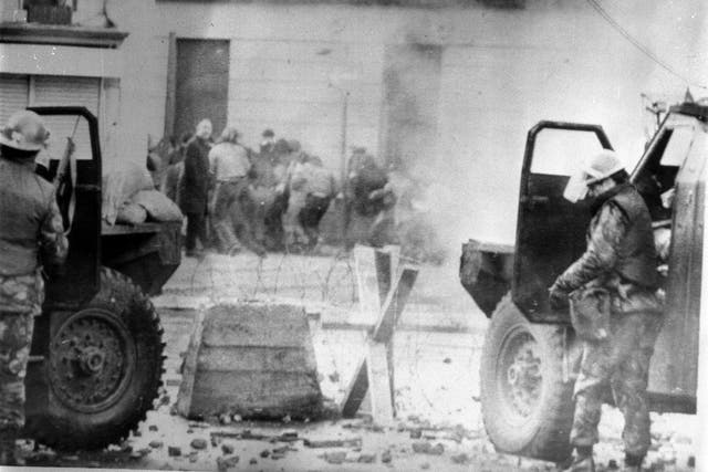 Soldiers take cover behind their sandbagged armoured cars in Londonderry on Bloody Sunday (PA)