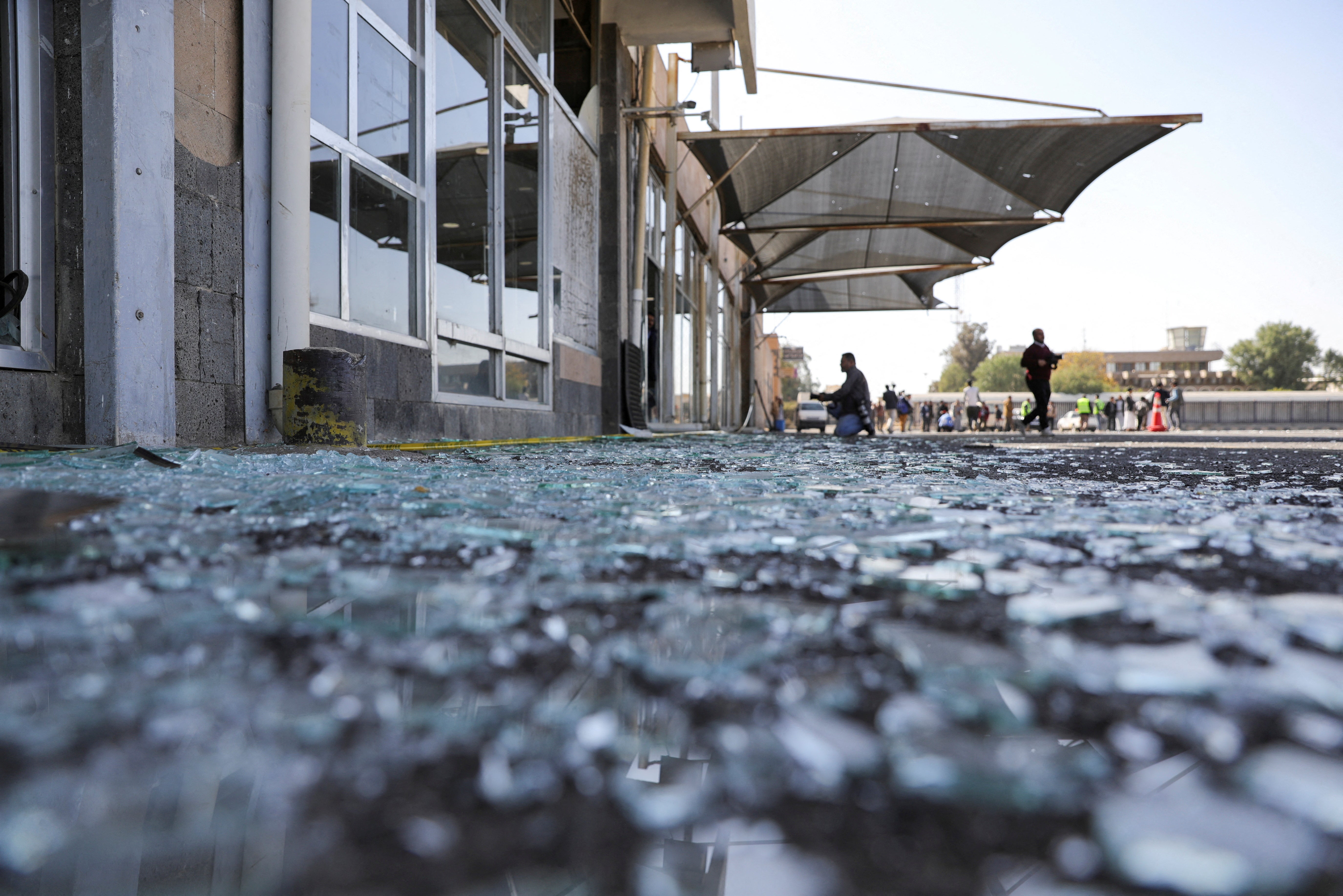 Shattered glass lies on the ground near damaged buildings of Sanaa Airport