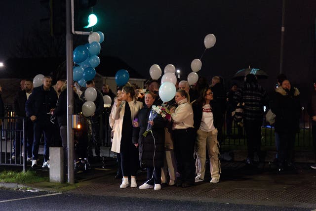 People attend a vigil at the scene on Blanchardstown Road North, west Dublin, where two pedestrians died in a hit-and-run on Boxing Day (Evan Treacy/PA)