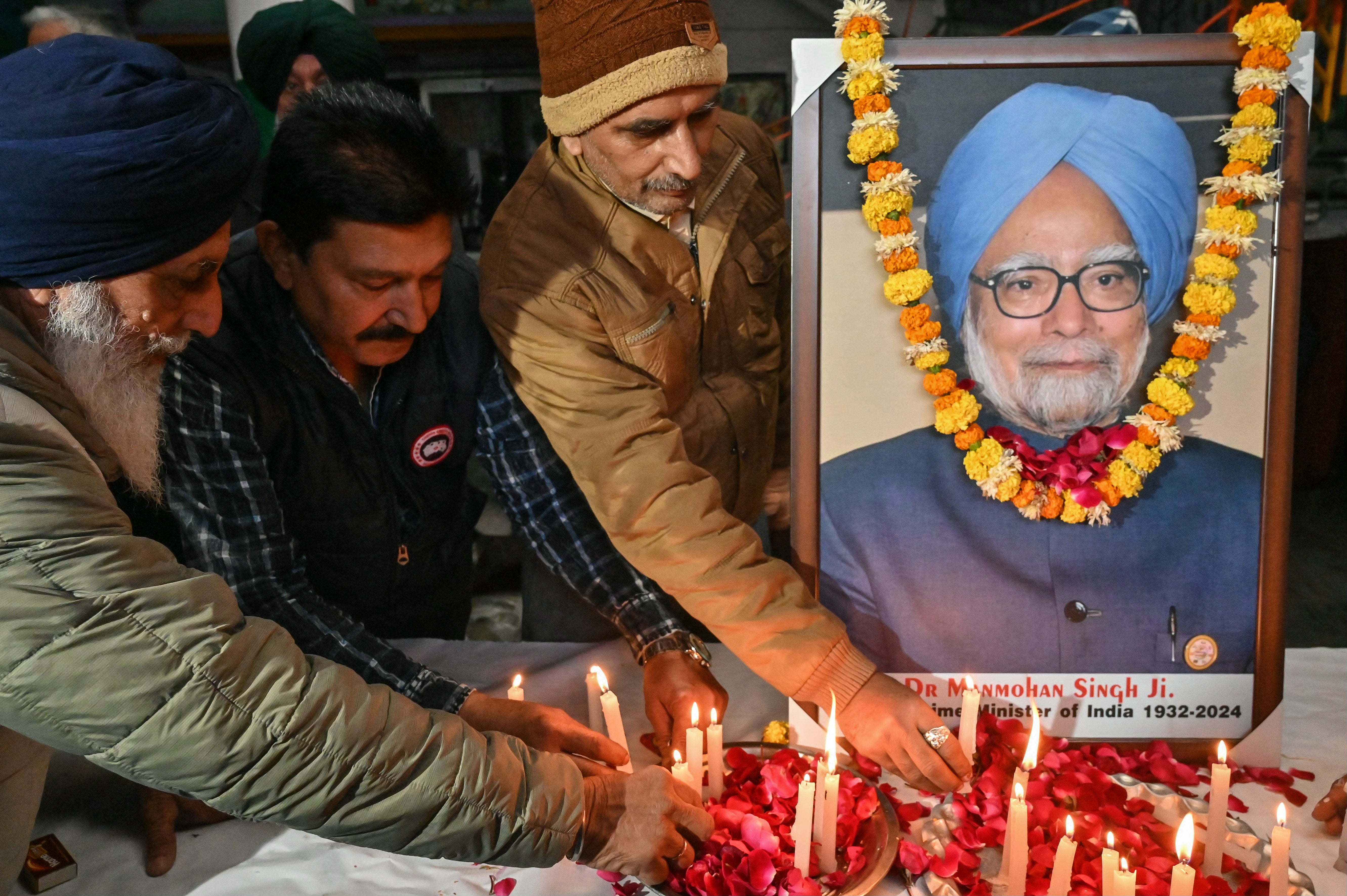 Members of Congress party light candles as they pay homage to late India’s former prime minister Manmohan Singh in Amritsar