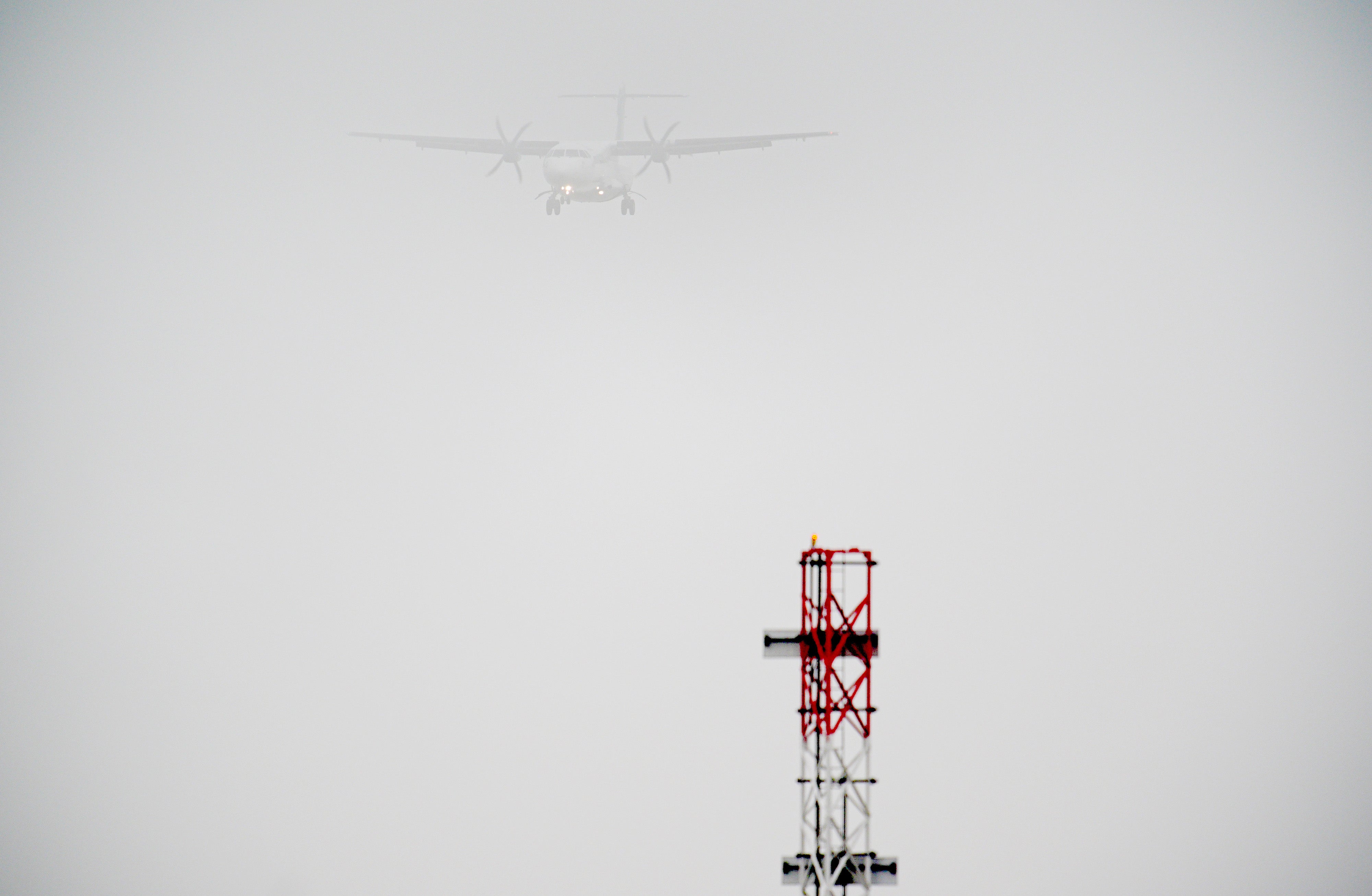 A plane lands in the fog at Cardiff Airport