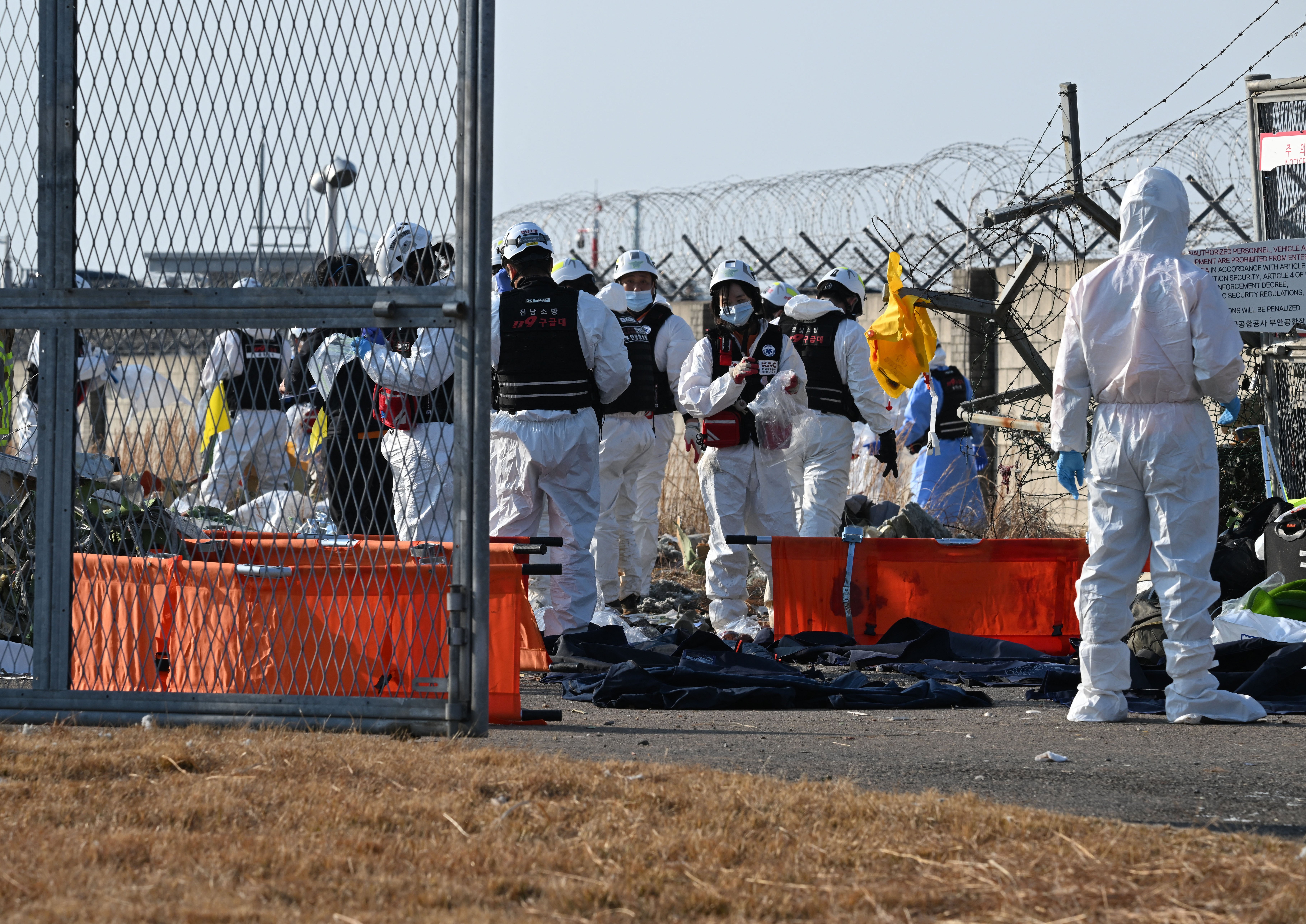 Firefighters and rescue personnel work near the scene where a Jeju Air Boeing 737-800 series aircraft crashed and burst into flames at Muan International Airport in South Jeolla province