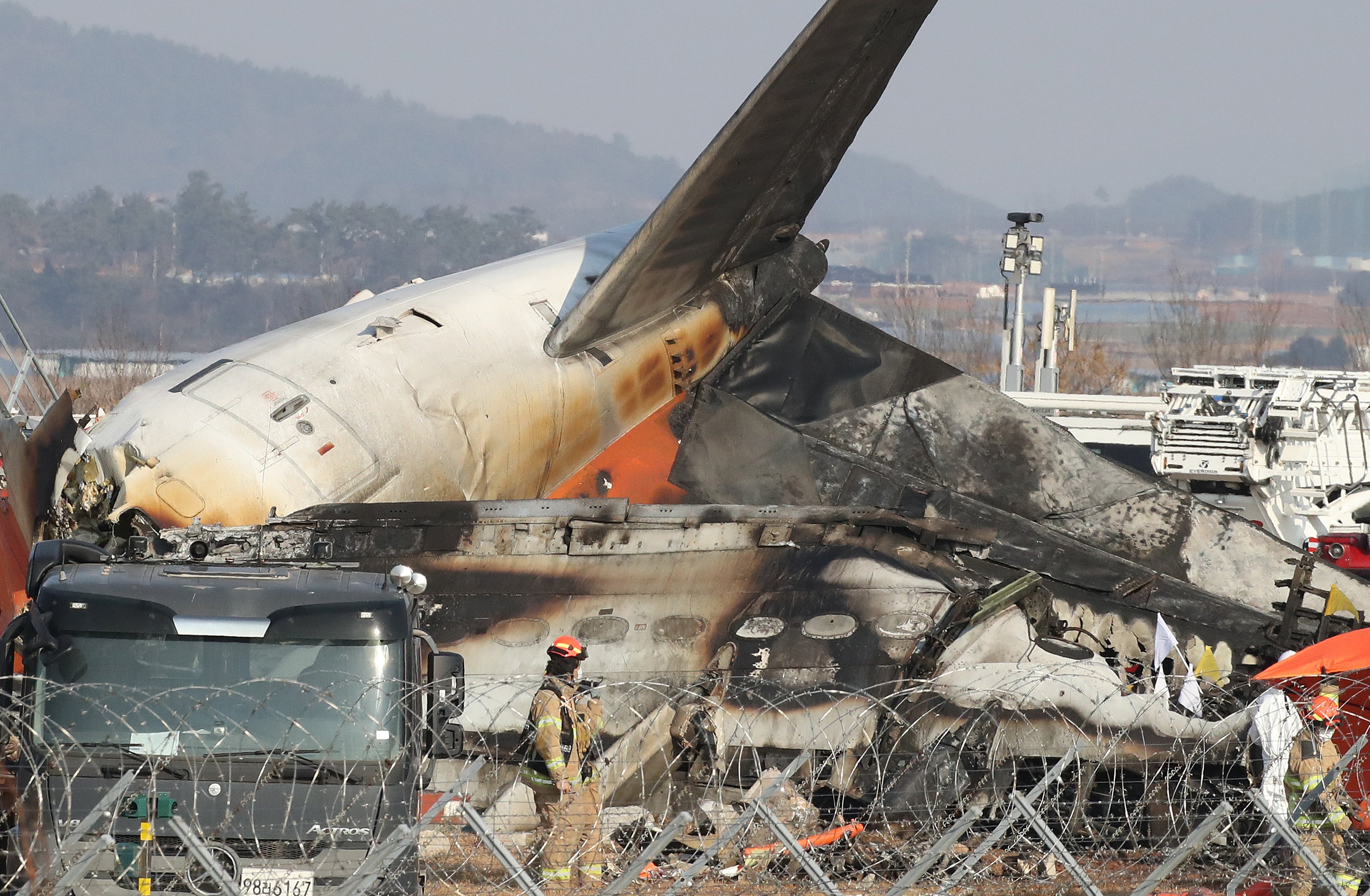 Firefighters check near the wreckage of a passenger plane at Muan International Airport in South Korea