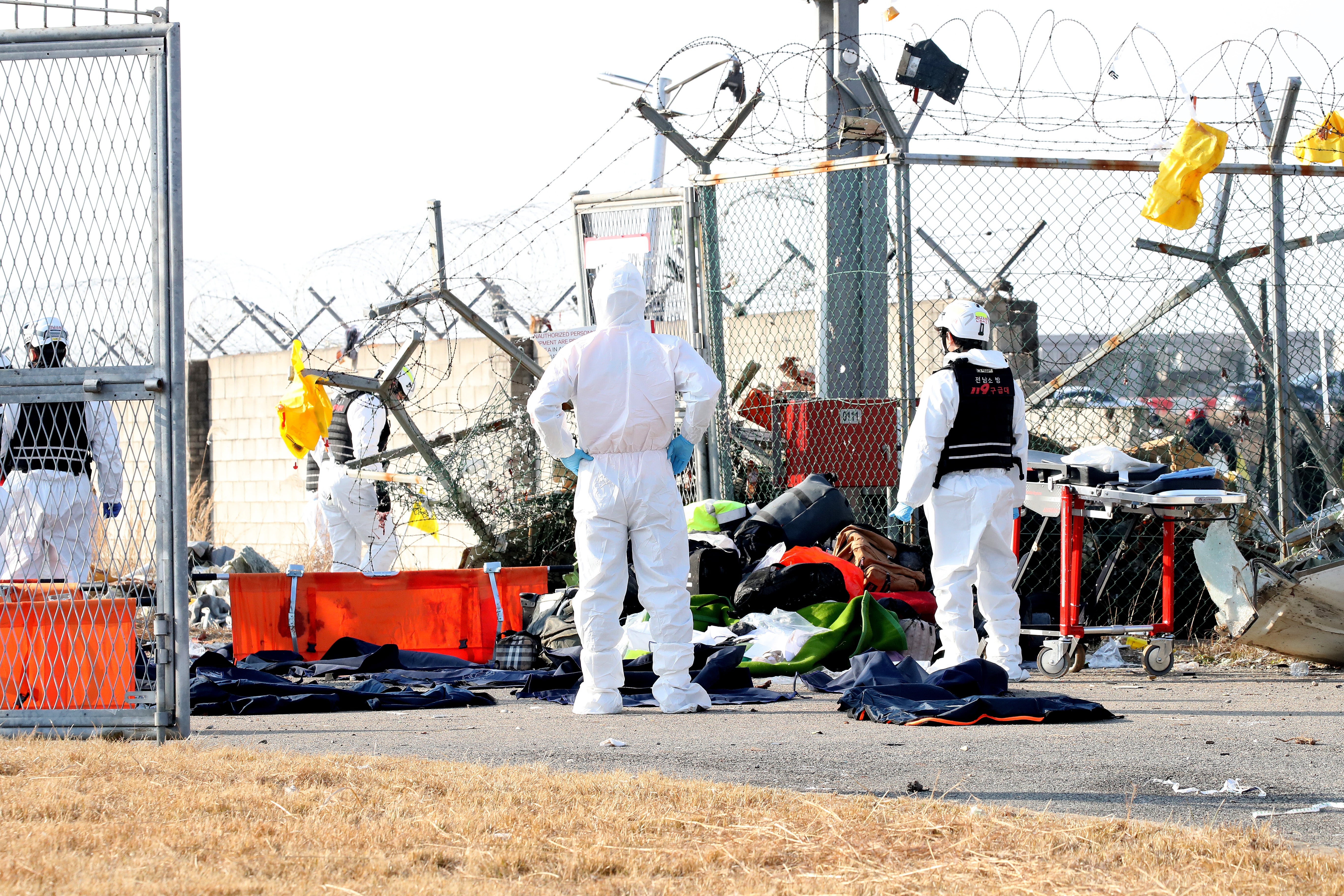 Firefighters check near the wreckage of a passenger plane at Muan International Airport