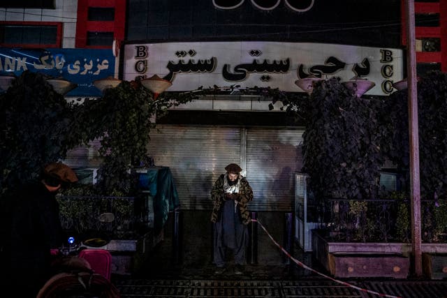 <p>An Afghan security personnel uses his phone at the site of an alleged blast in Kabul</p>