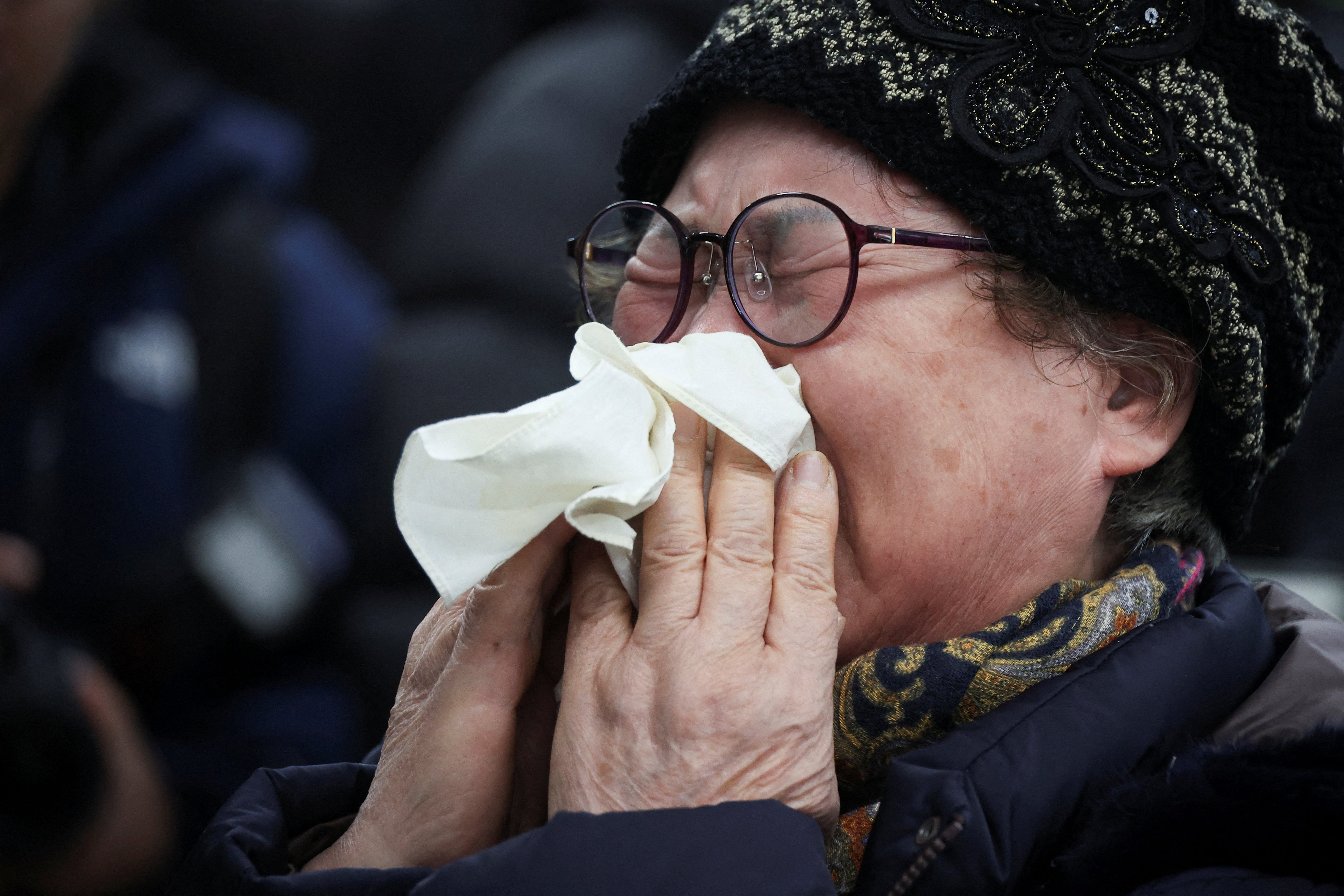 A relative of a passenger of the aircraft that crashed after it went off the runway, reacts at Muan International Airport, in Muan, South Korea