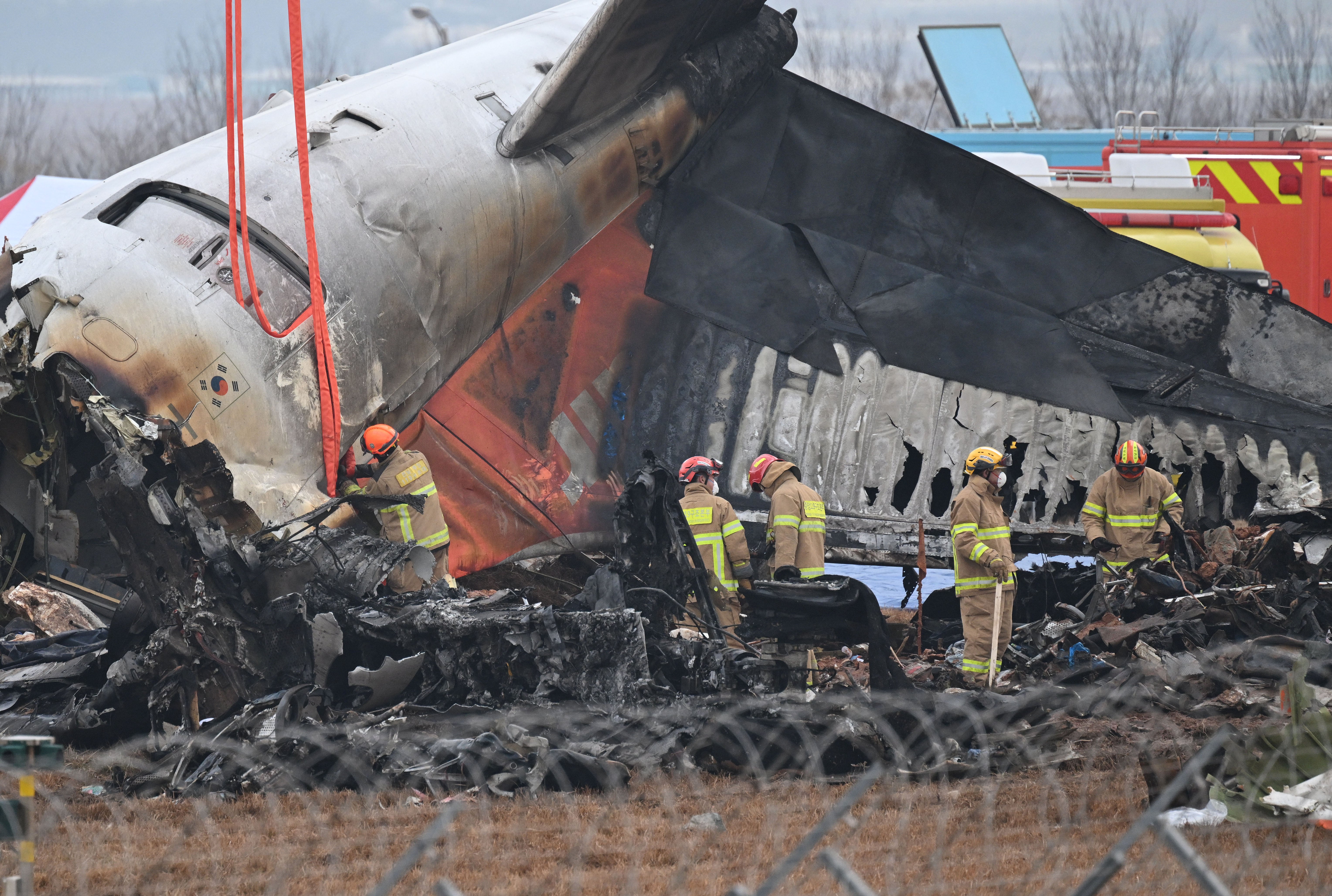 Firefighters and recovery teams work at the scene where a Jeju Air Boeing 737-800 series aircraft crashed