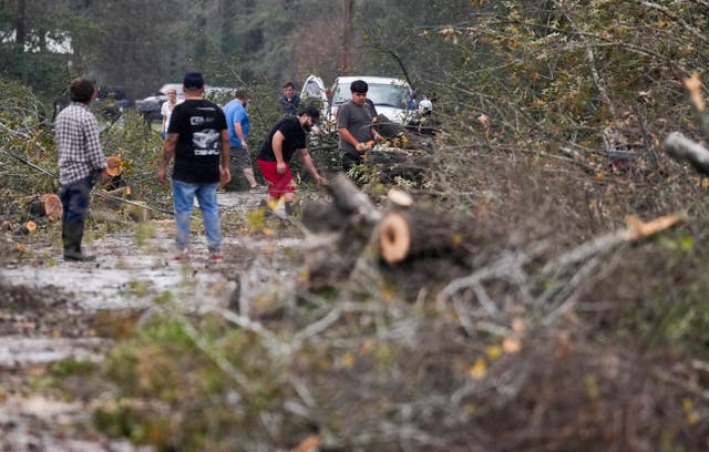 <p>People clear a street after trees fell following storms near Houston, Texas, on Saturday. The severe weather brought deadly tornadoes to the Lone Star State and other parts of the South </p>