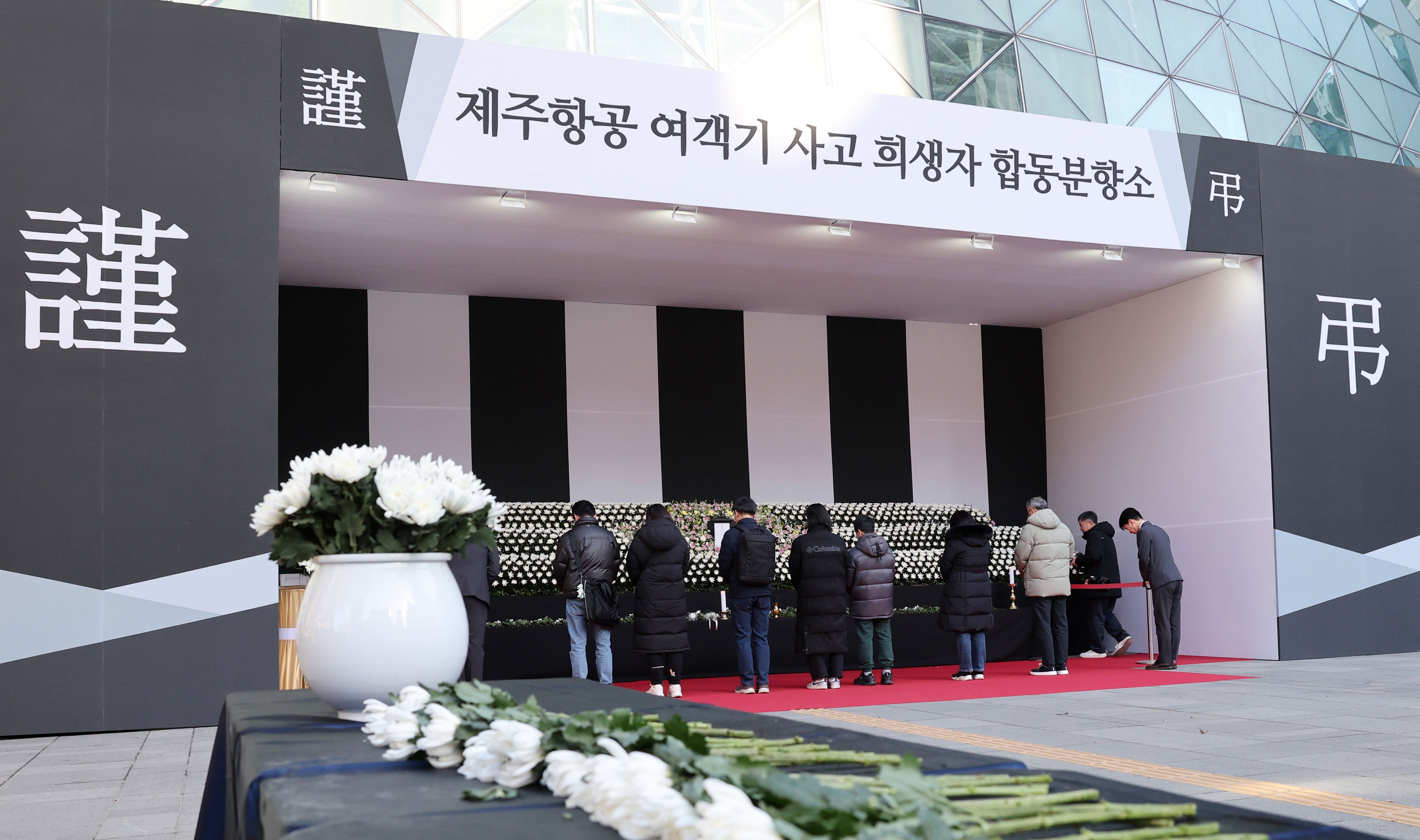 People pay tribute to the victims of the 29 December Jeju Air passenger plane crash at a memorial altar in front of Seoul City Hall