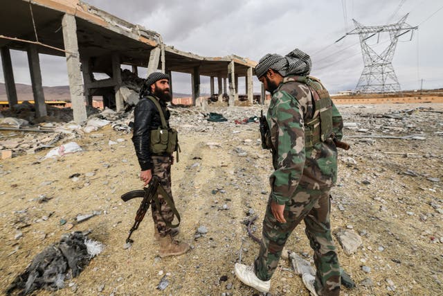 <p>Fighters affiliated with Syria's new regime inspect the damage at the site of an explosion</p>