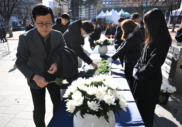 <p>Mourners pay their respects at a memorial altar for the victims of the Jeju Air plane crash</p>