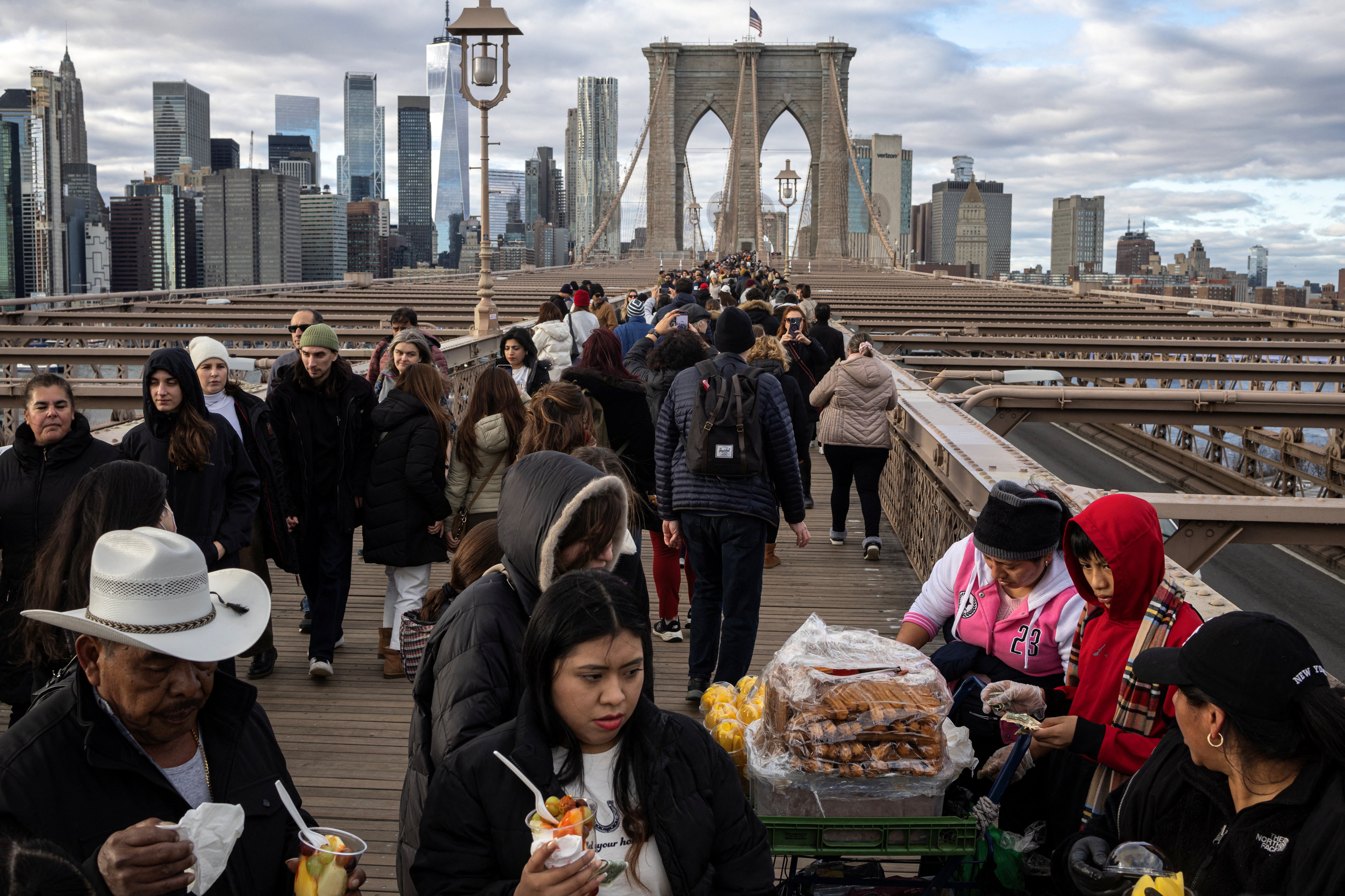 People walking over the Brooklyn Bridge in New York City on Monday. New York is one of several major metro areas that could see snowfall next month