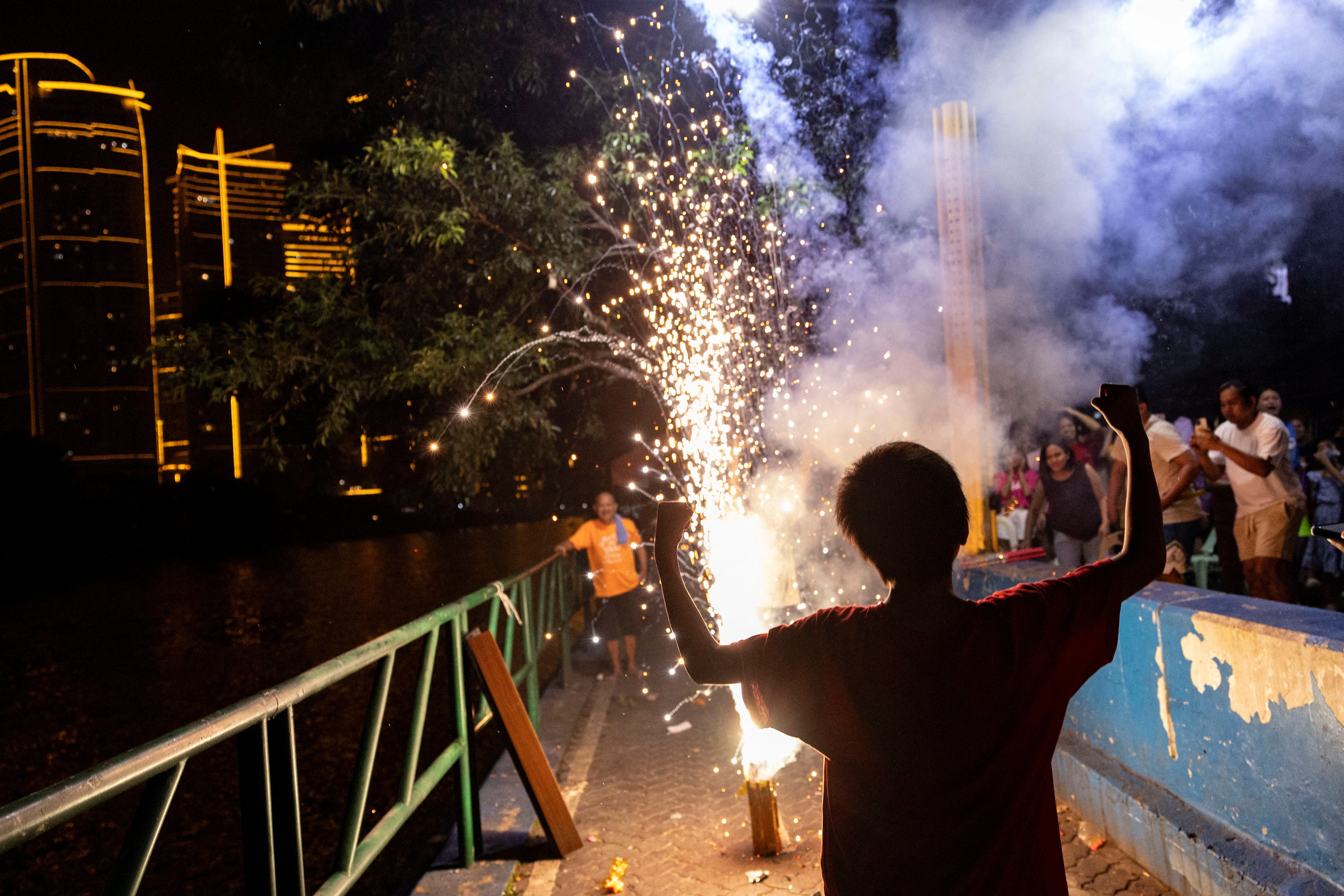 A reveller celebrate the New Year with firecrackers in Mandaluyong City