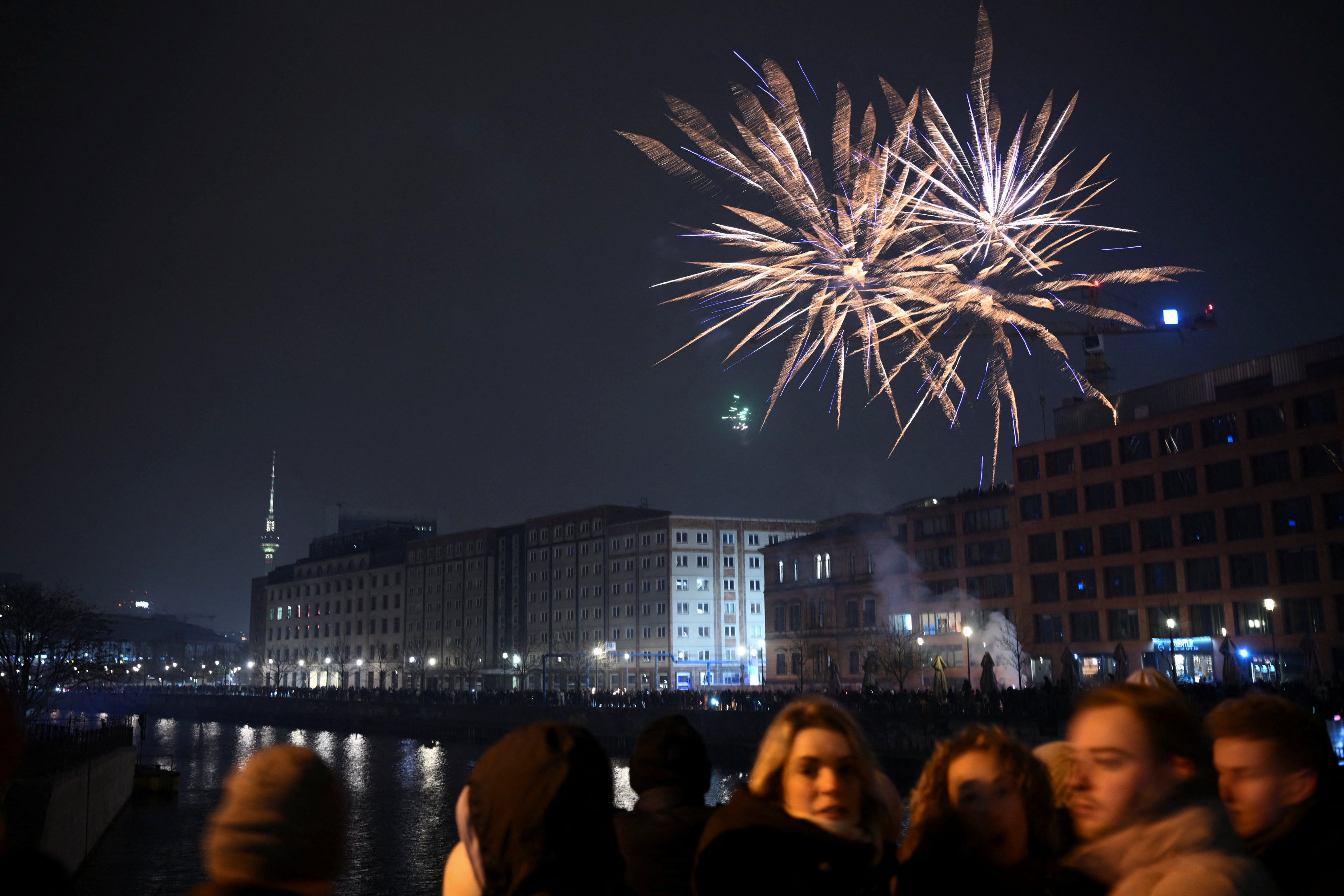 Fireworks burst as people gather for New Year's celebrations in Berlin