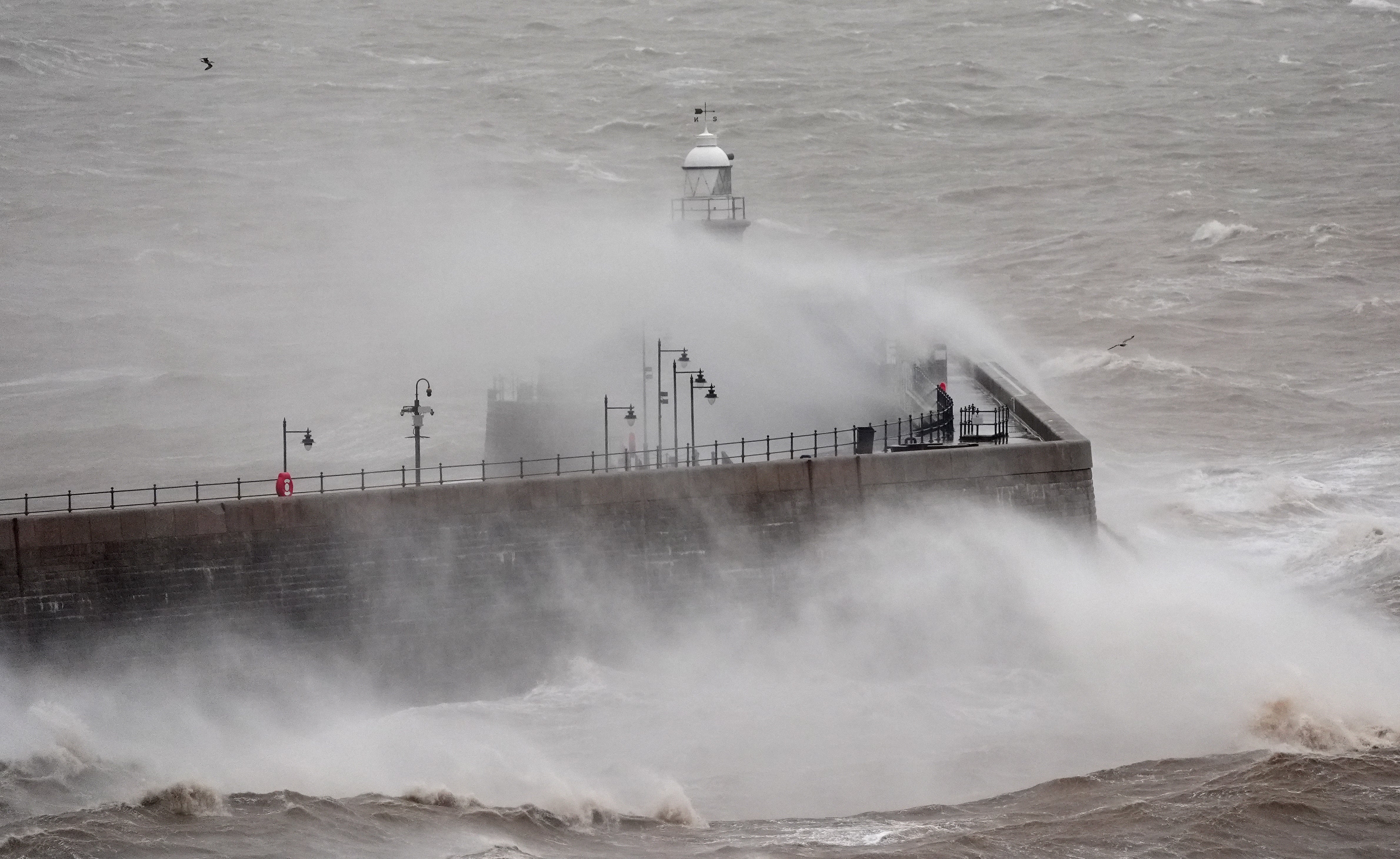 <p>Waves crash against Folkestone harbour wall in Kent on New Year’s Day </p>