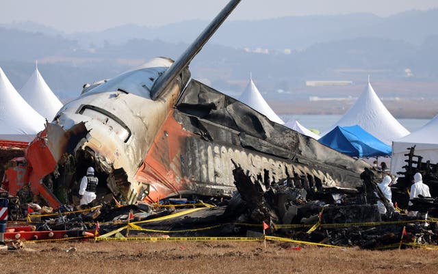 <p>Investigators at the site where a Jeju Air Boeing 737-800 aircraft crashed in South Korea </p>