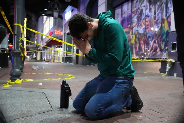 <p>A man praying at the scene of an attack in New Orleans which left 15 people dead  </p>