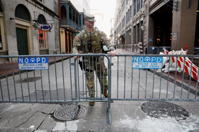 <p>A National Guard military police officer stands guard behind a New Orleans Police Depratment barrier on Bourbon Street </p>