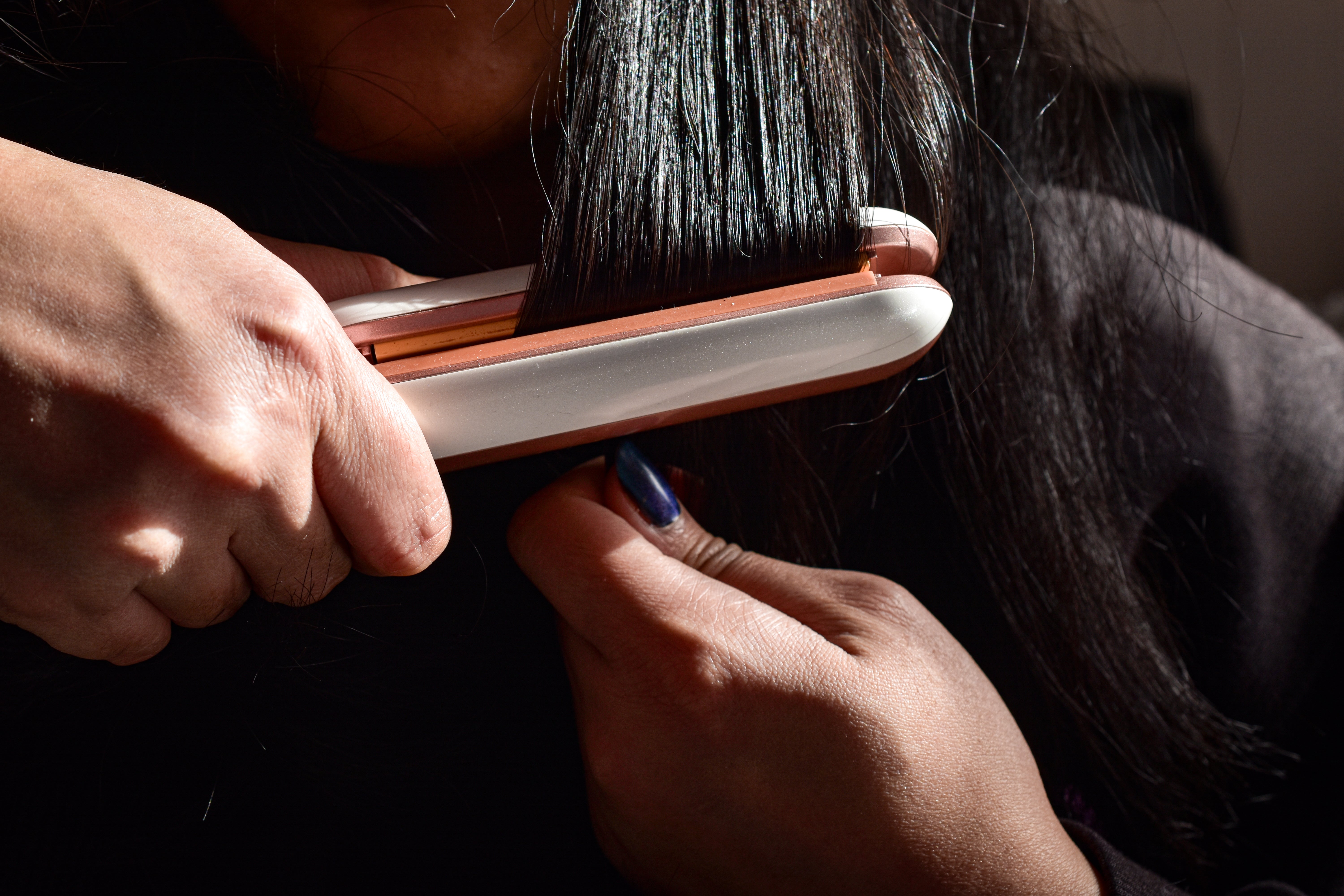 A woman uses a flat iron to straighten her hair. Formaldehyde, a dangerous chemical found ‘nearly everywhere’ and used to help smooth curls, has been determined to present an ‘unreasonable risk of injury to human health, the Environmental Protection Agency said Thursday