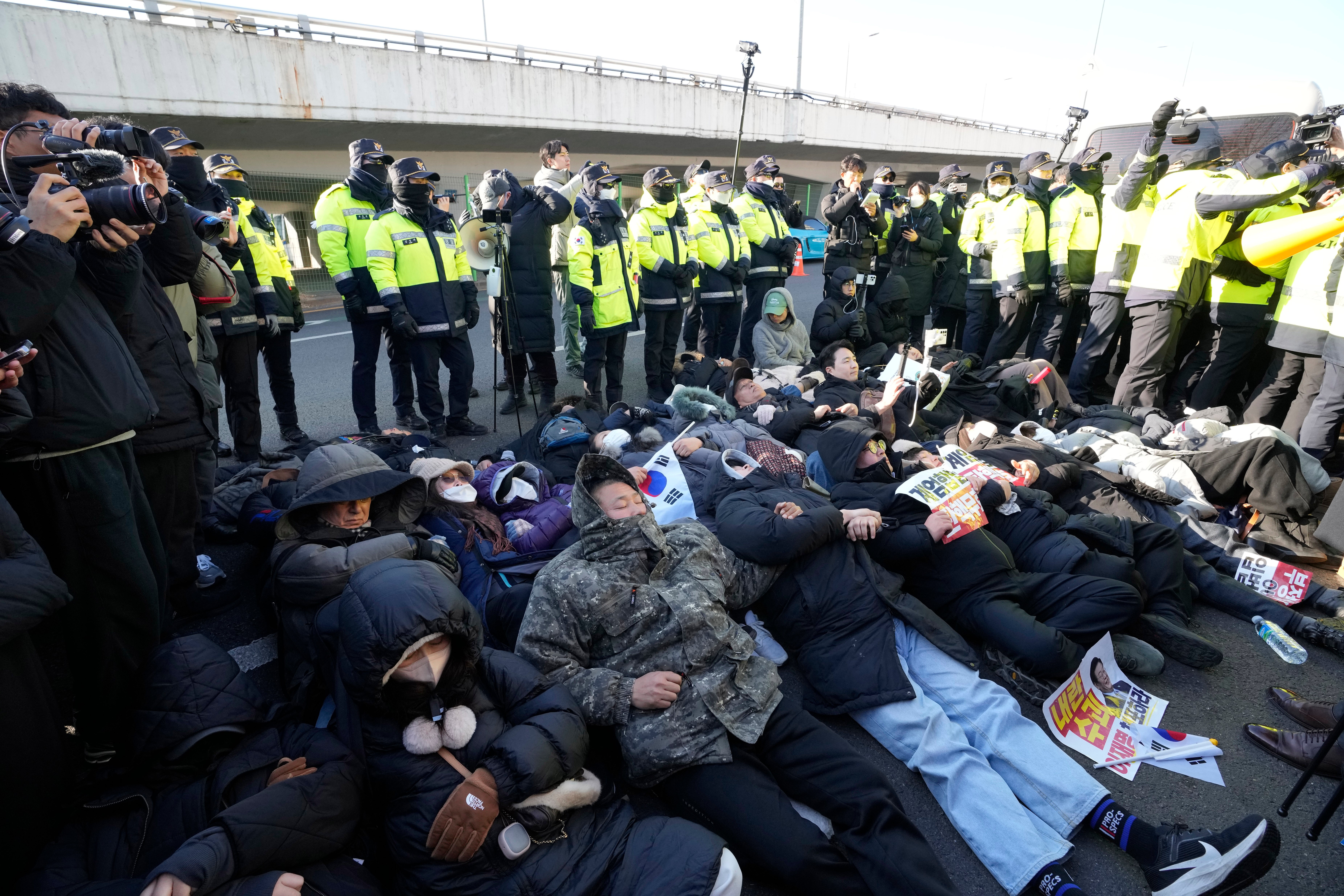 Supporters of impeached Yoon Suk Yeol lie down on the ground during a protest rally outside the presidential palace in Seoul