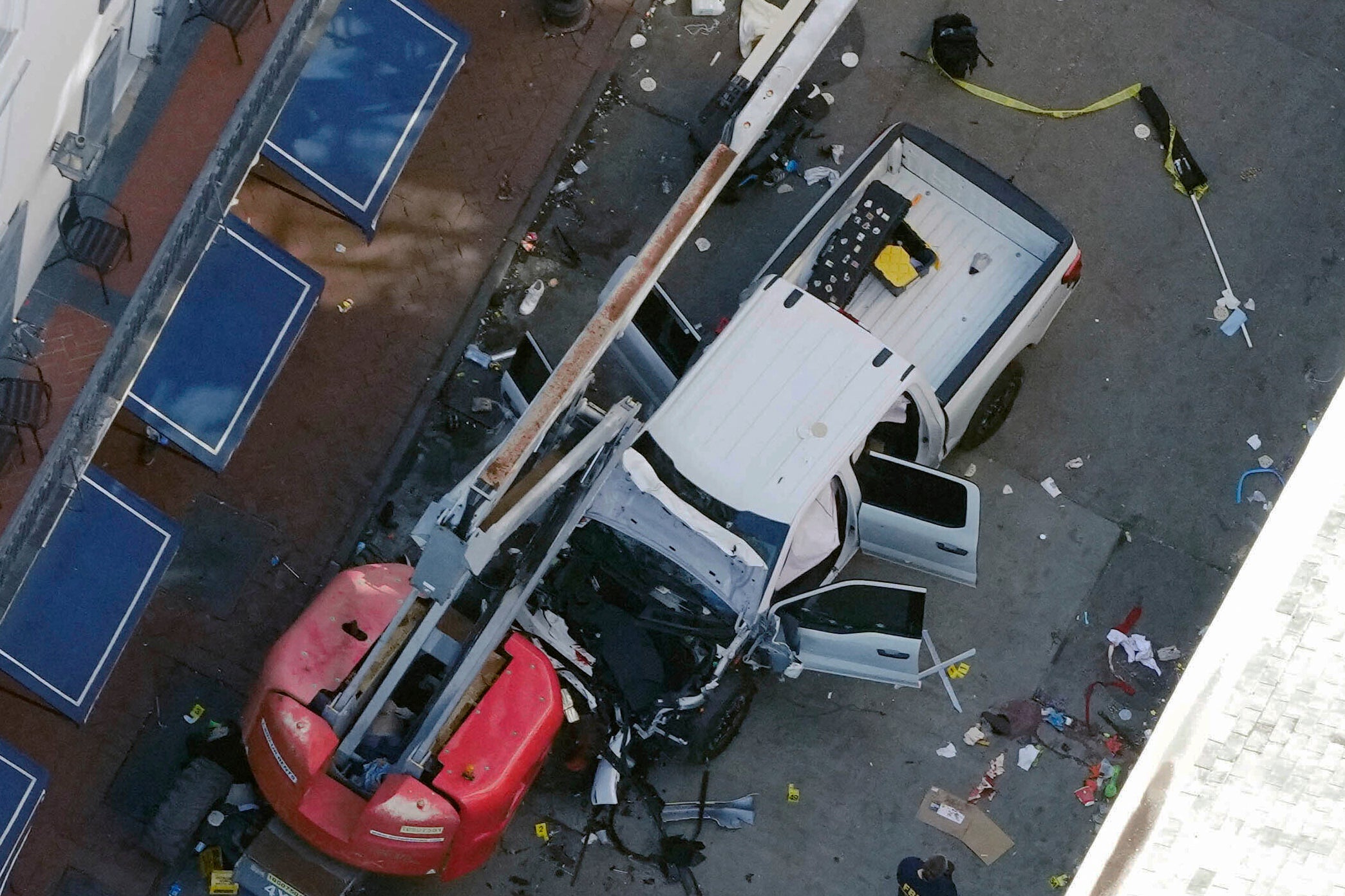 A black flag with white lettering lies on the ground rolled up behind a pickup truck that a man drove into a crowd on Bourbon Street in New Orleans, killing and injuring a number of people, early New Year’s Day.