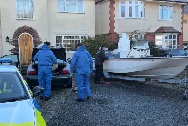 Forensic officers carry out searches of a boat and car on the driveway of a house in Poole (Ben Mitchell/PA)
