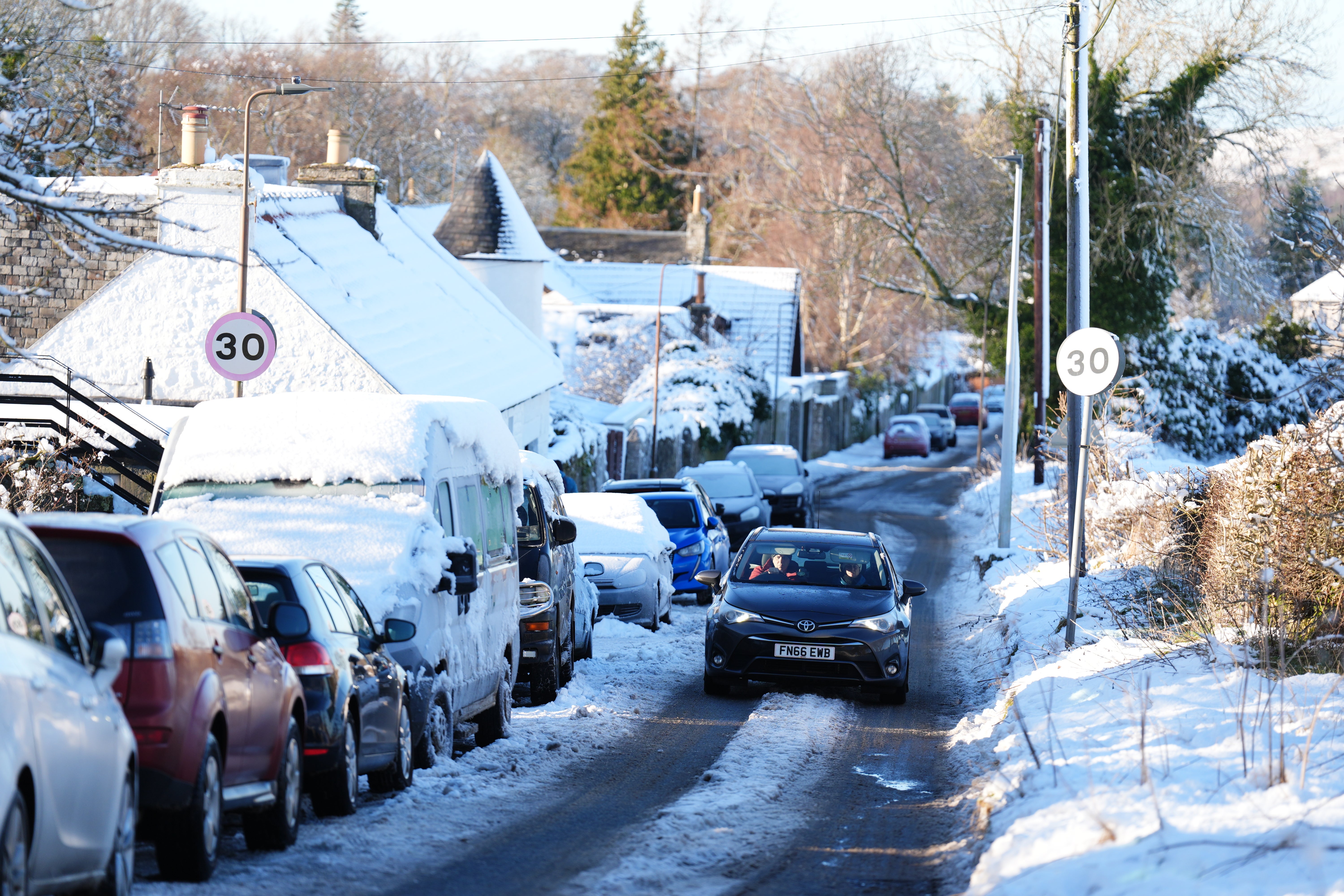 A car drives through snow in Balerno, Edinburgh on Friday