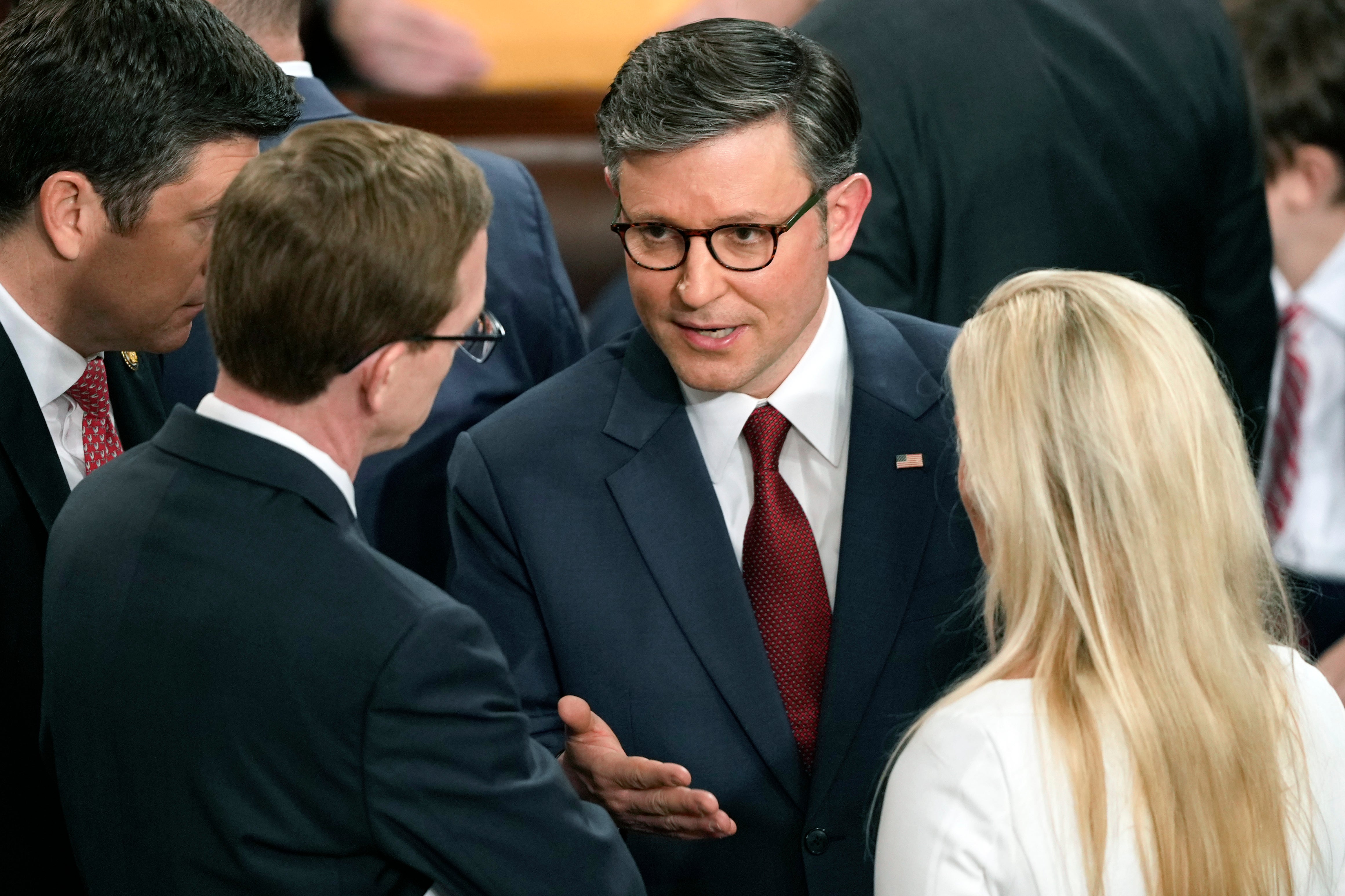 House Speaker Mike Johnson speaks with Rep. Dusty Johnson, R-S.D., left, and Rep. Marjorie Taylor Greene R-Ga