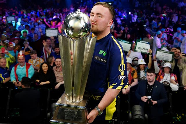 Luke Littler kisses the Sid Waddell Trophy after winning the World Championship (Zac Goodwin/PA)