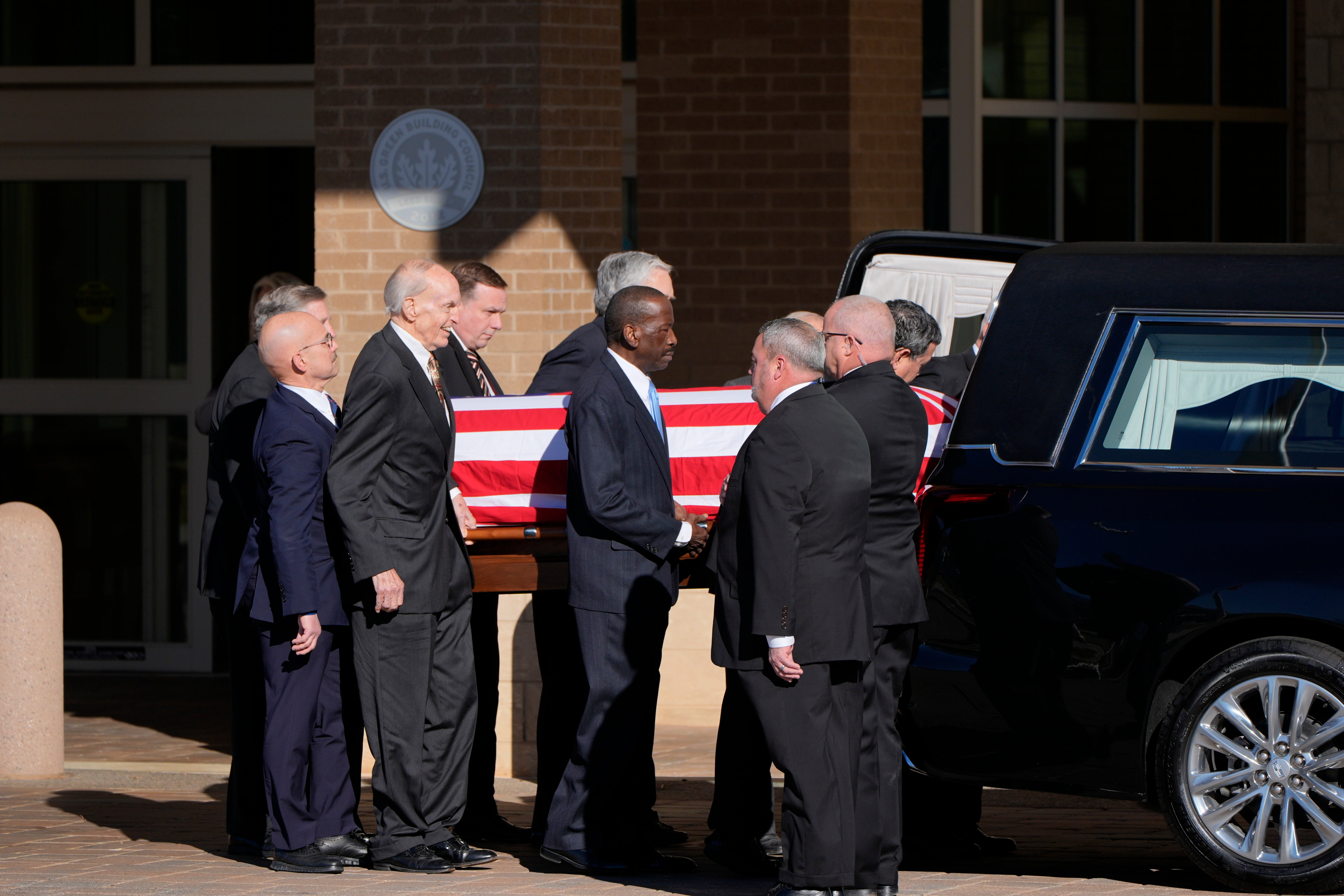 Former and current Secret Service agents assigned to President Jimmy Carter’s detail move his remains into a hearse on Saturday morning