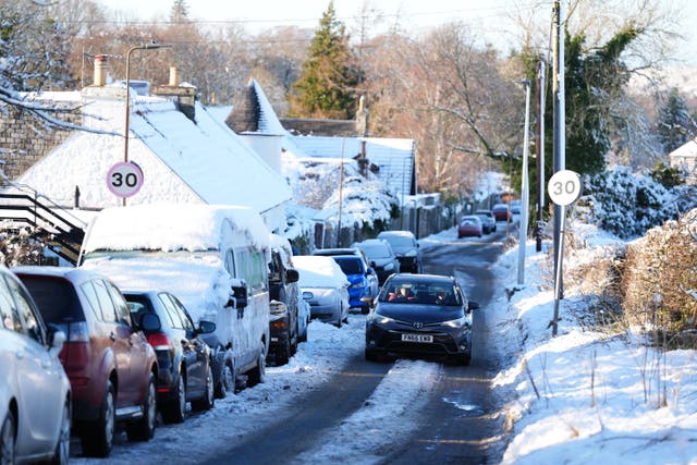 <p>A car drives through snow in Balerno, Edinburgh amid freezing conditions across the UK </p>