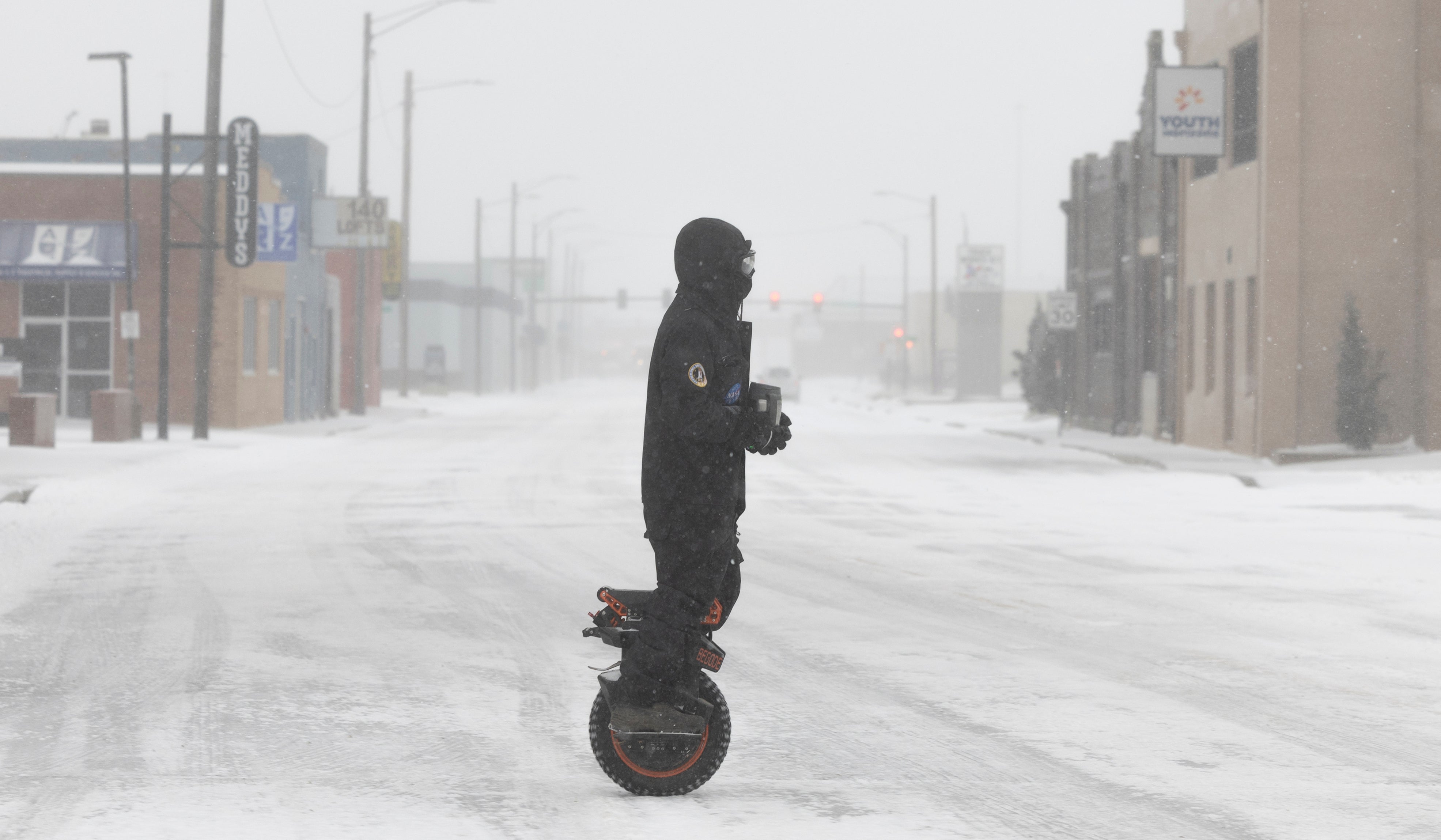 A rider makes his way through Wichita, Kansas on a one-wheel electric scooter in blizzard-like conditions on Sunday morning