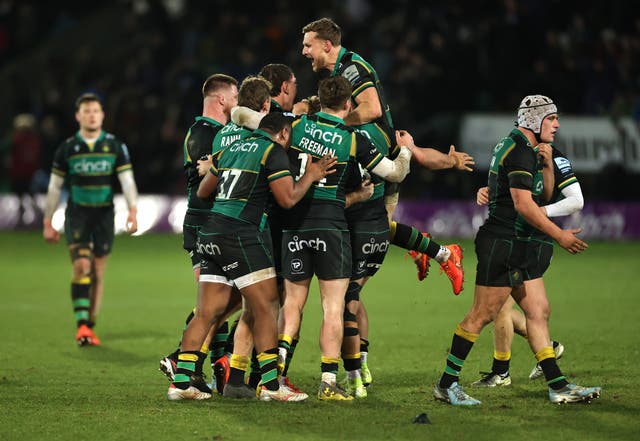 <p>Northampton Saints players celebrate after Fin Smith kicks the match-winning penalty</p>