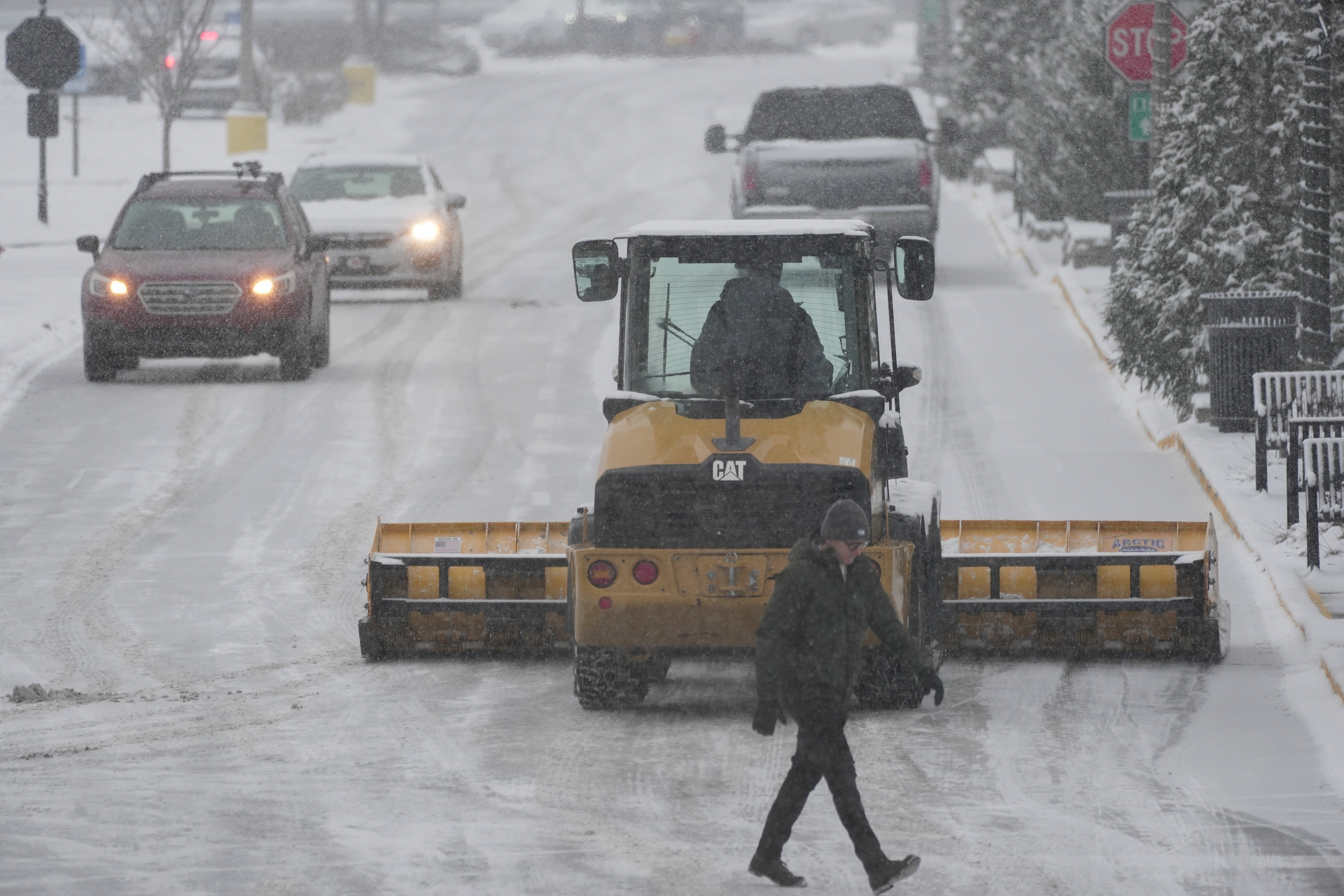 A snow plow clears a parking lot in Cincinnati on Sunday. Cincinnati and the surrounding area are under a winter storm warning for the rest of Sunday