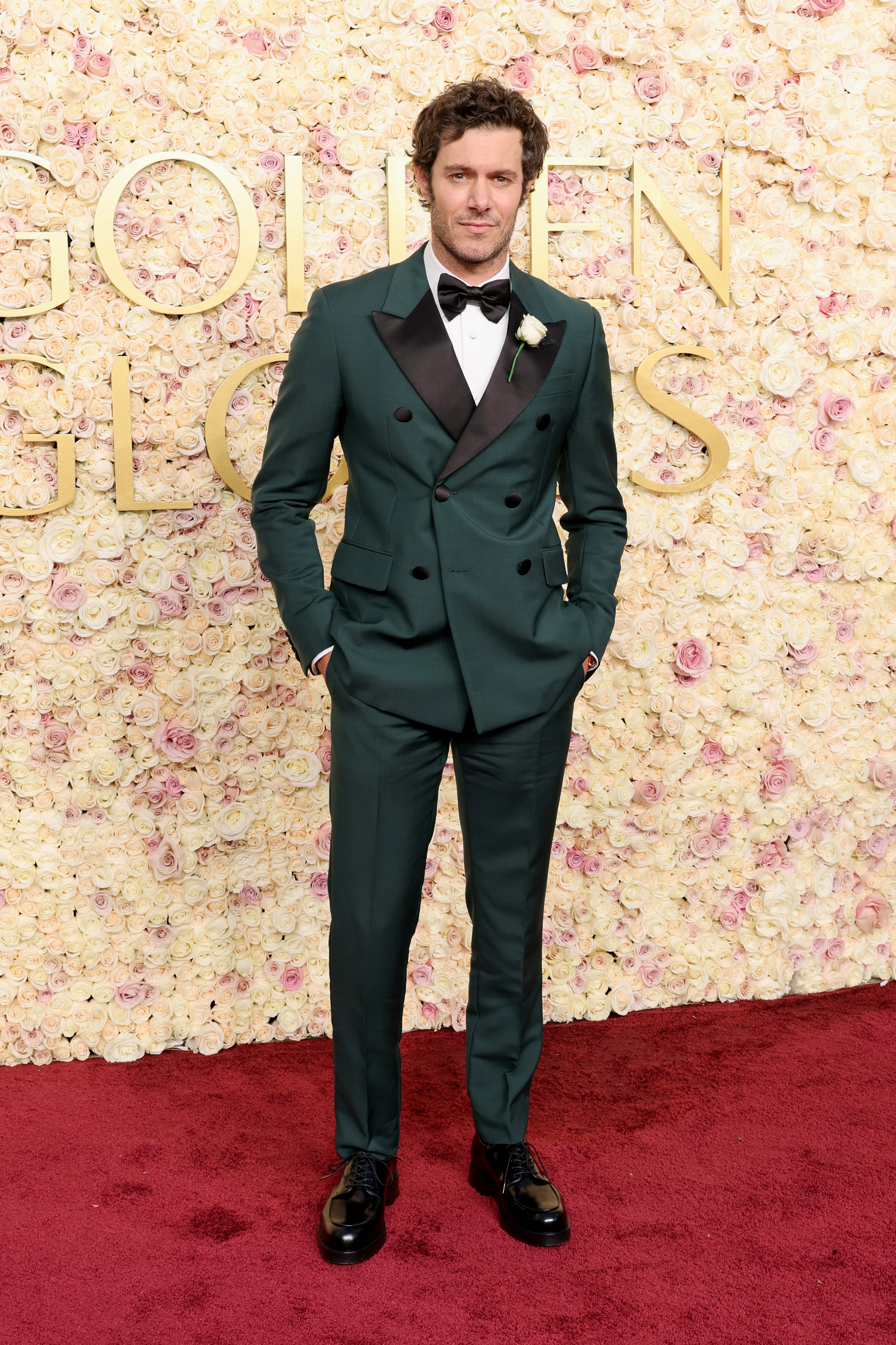 Adam Brody arrives in a forest green tuxedo to the 2025 Golden Globes