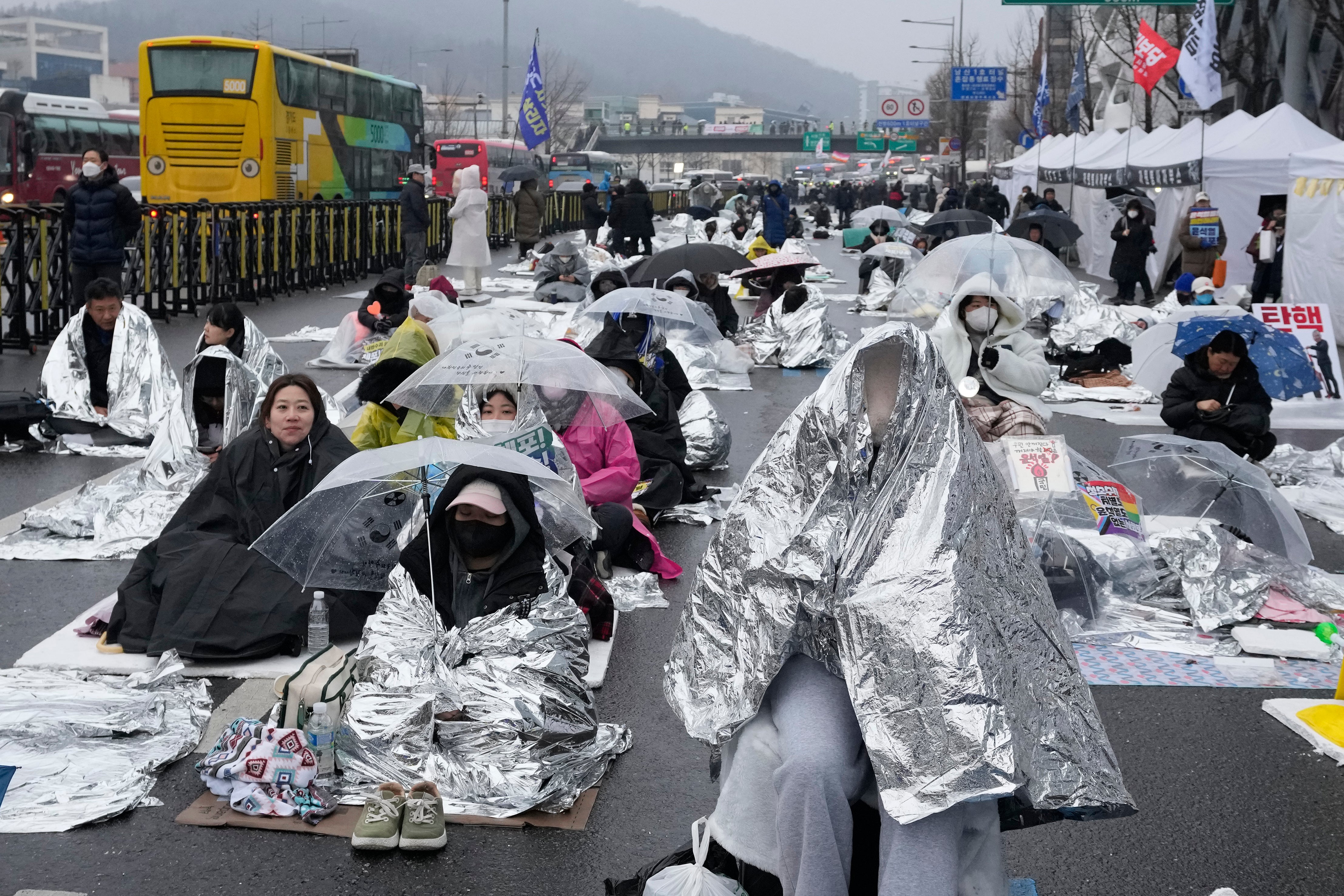 Protesters wait for a rally demanding the arrest of impeached South Korean President Yoon Suk Yeol near the presidential residence in Seoul, South Korea, Monday, Jan. 6,