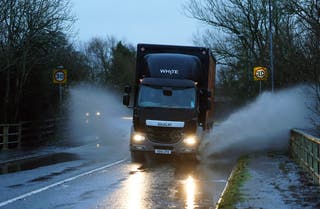 Motorists drive through standing water in Upton upon Severn, Worcestershire, on Monday