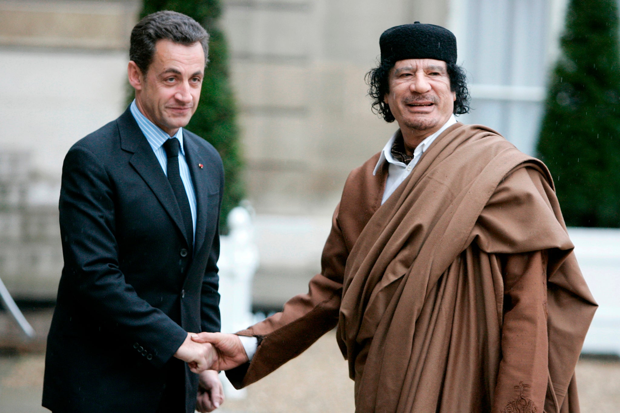 French President Nicolas Sarkozy greets Libyan leader Muammar Gaddafi upon his arrival at the Elysee Palace in December 2007