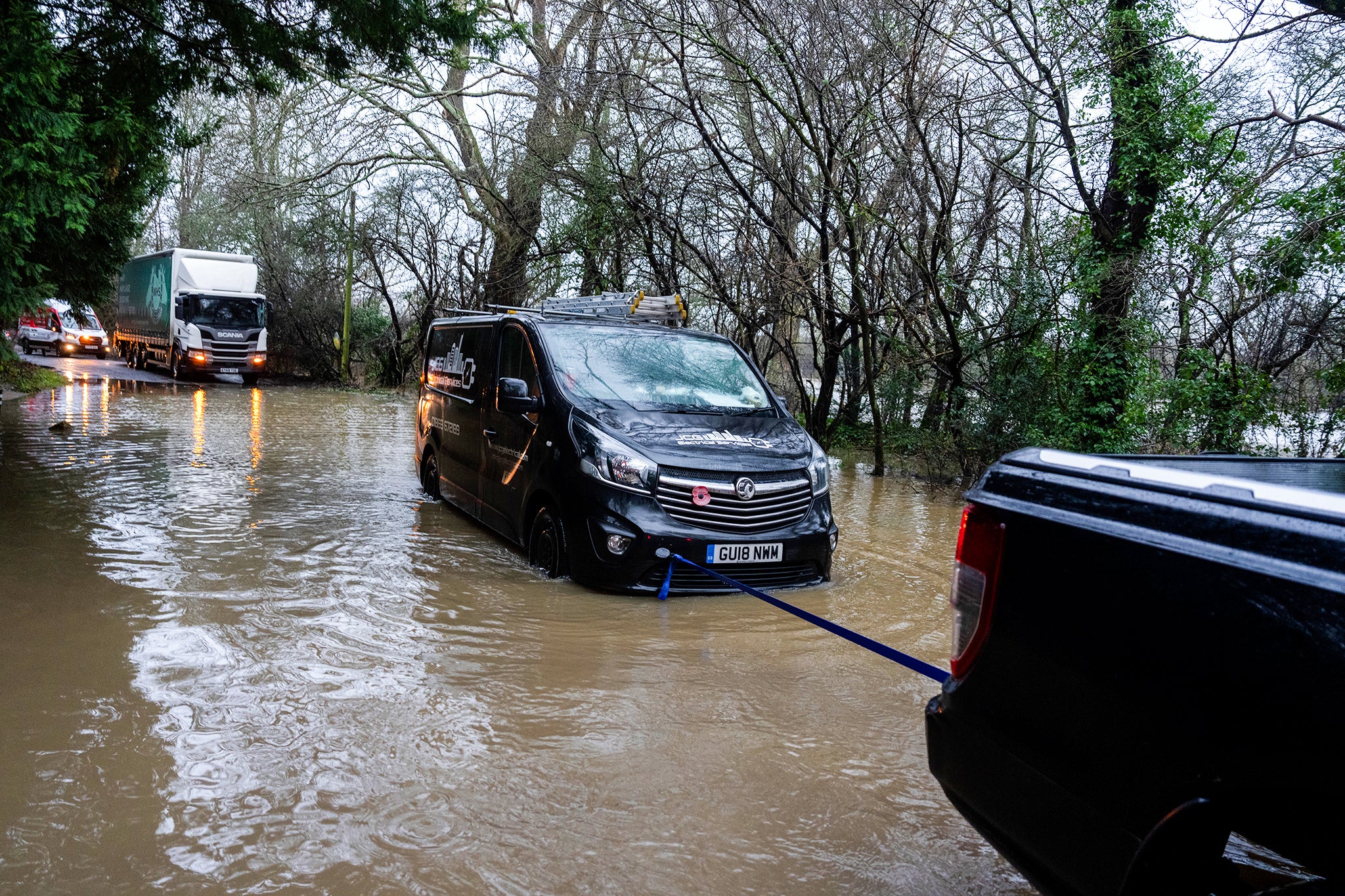 Sebuah van ditarik setelah terjebak di jalan banjir di Lingfield pada hari Senin