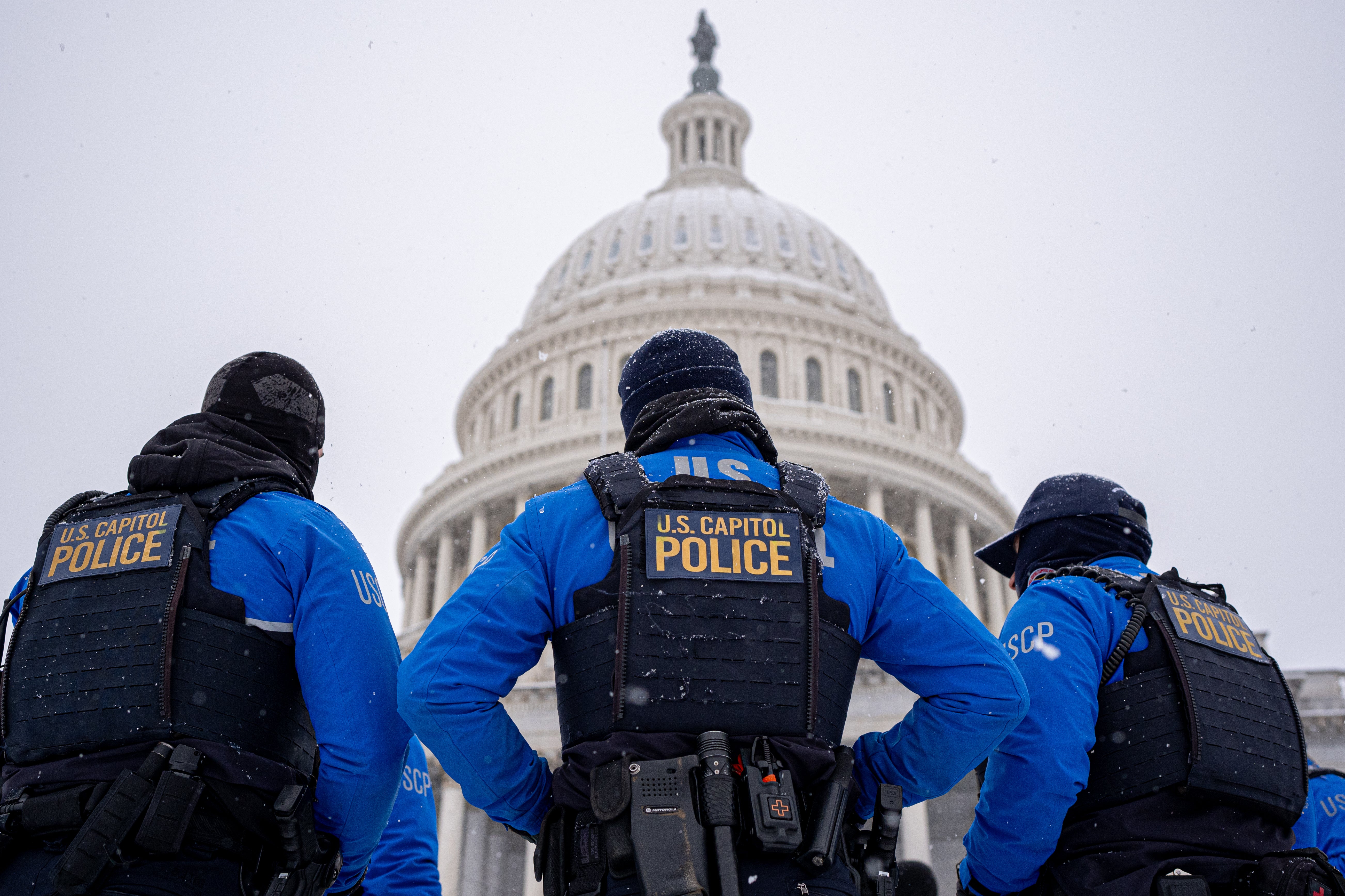 Three police officers stand in front of the U.S. Capitol Building on Monday in Washington, D.C. Monday marks the fourth anniversary since rioters stormed the Capitol