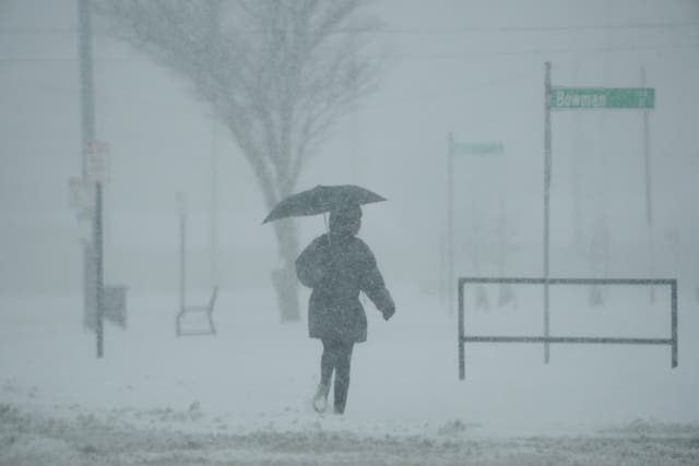 <p>A person holds an umbrella on Monday as they walk during a winter storm in Cincinnati, Ohio. Severe weather resulted in the deaths of several people and majorly disrupted air and ground travel </p>